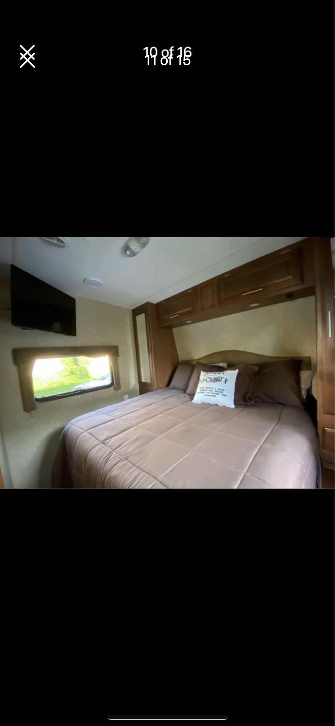 Inside a cozy RV rental bedroom featuring a bed with brown bedding, overhead storage, TV, and a scenic window view.. Eclipse Recreational Vehicles Attitude 2017