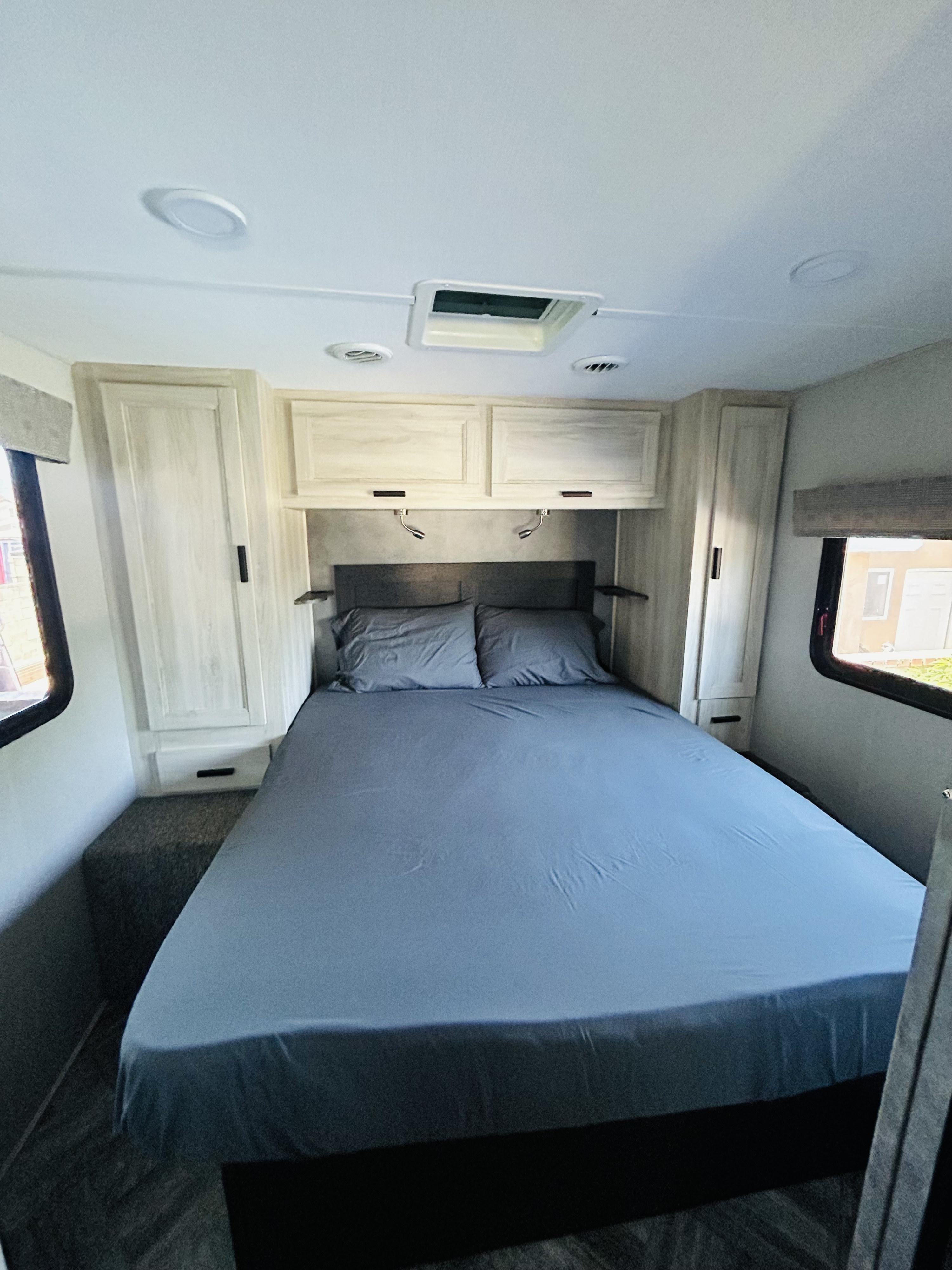 RV rental bedroom: A clean, modern interior with a bed, cabinets, overhead lighting, and windows.. Forest River Sunseeker LE 2022