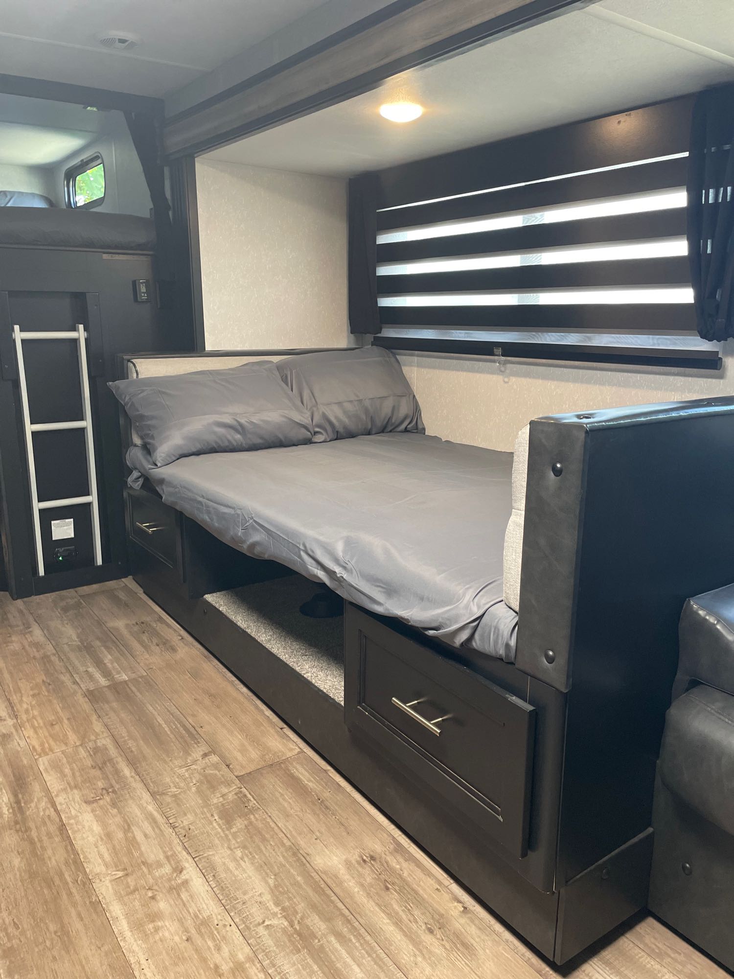 Explore this cozy RV rental bunk bed area with lower bed, pull-out storage, upper bunk ladder, and wood flooring.. Forest River Cherokee Grey Wolf Black Label 2021