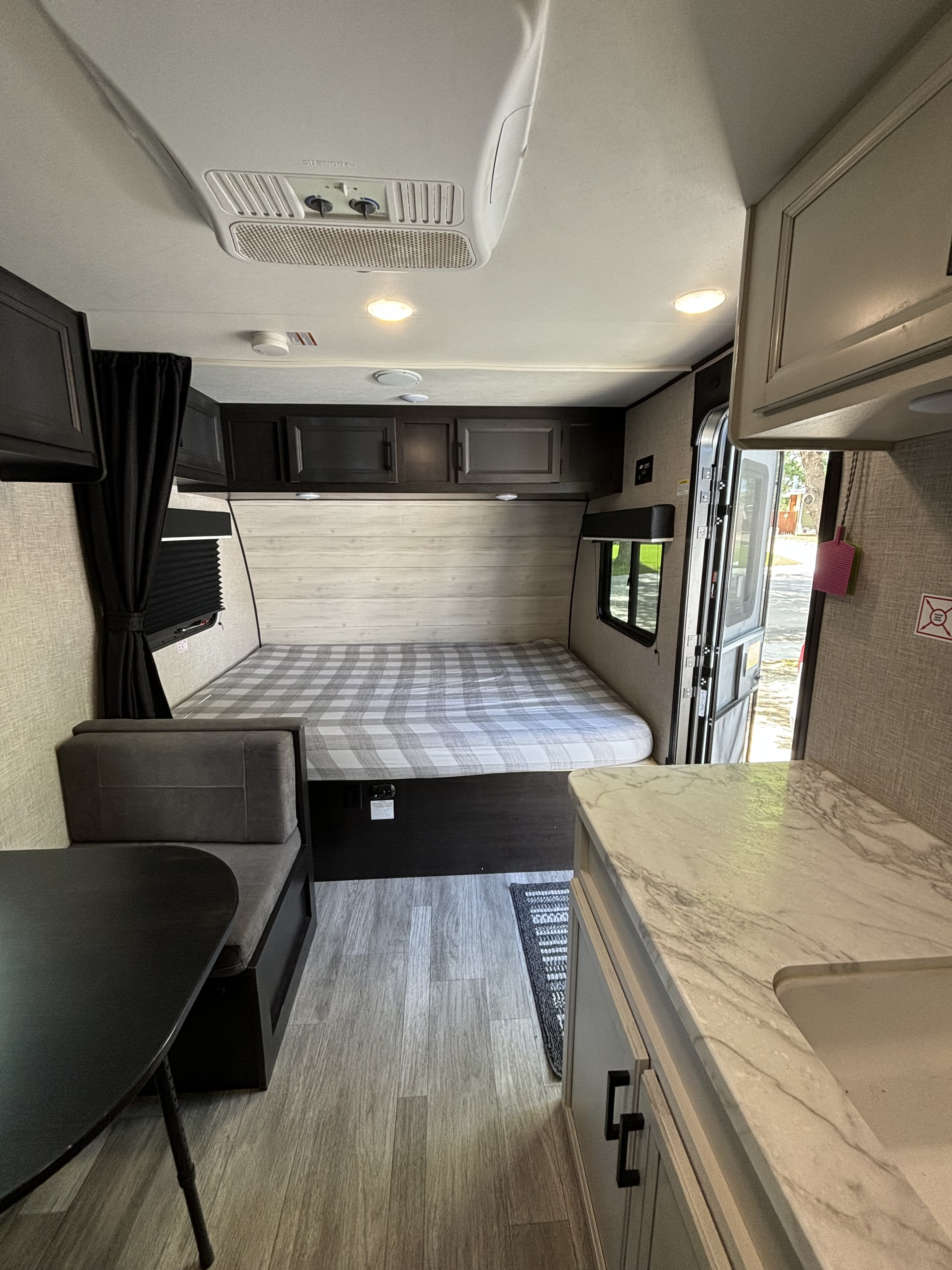 Experience comfort in this RV rental's well-designed interior, featuring a cozy bed, dinette, and compact kitchen.. Jayco Jay Flight SLX 2023