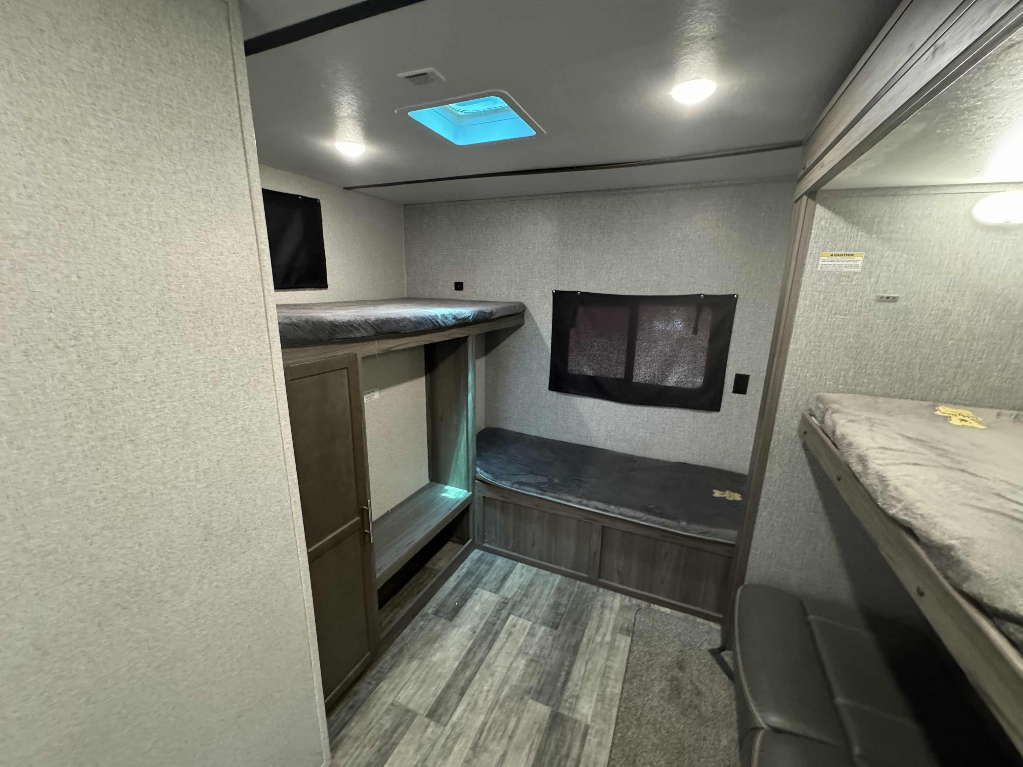 This RV rental bunkhouse features cozy beds, storage, and a skylight, perfect for family travel.. Crossroads RV Volante 2020