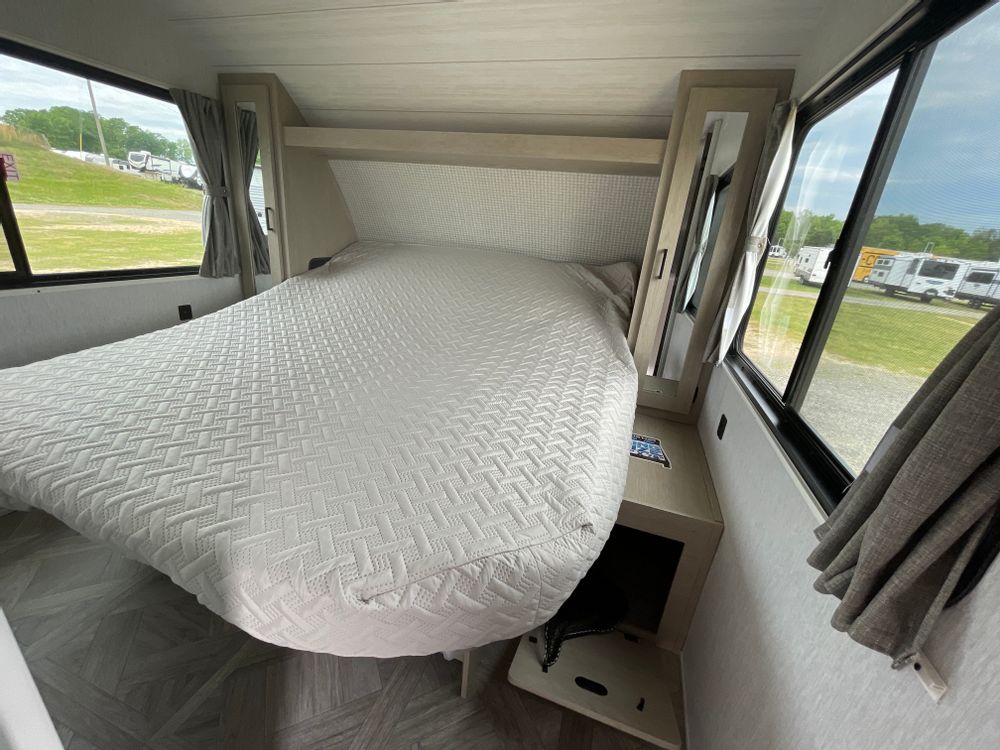 RV rental bedroom: bright and spacious with a large bed, white quilted cover, wide windows, and bedside storage.. Forest River Salem Cruise Lite Platinum 2024