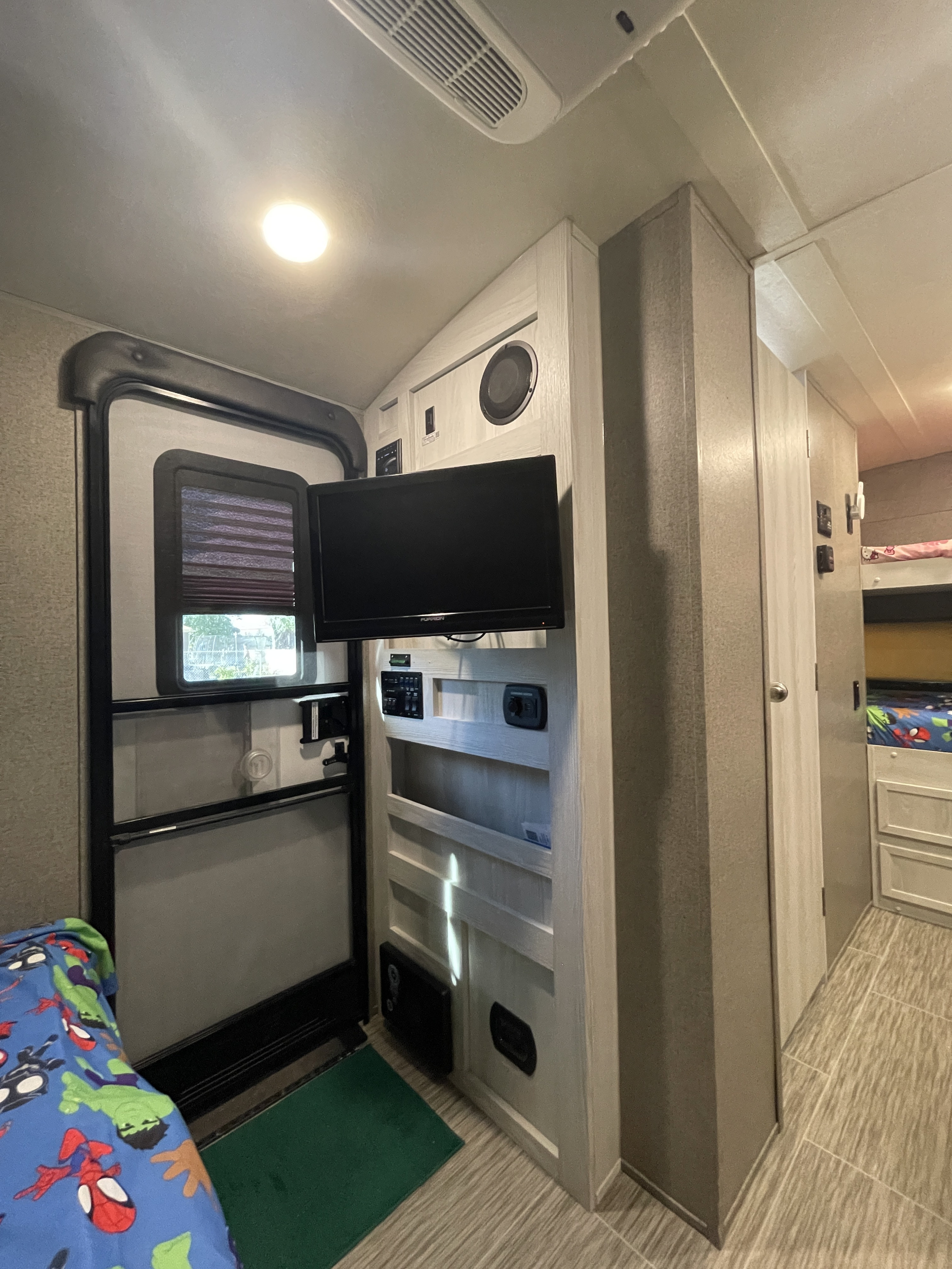 RV rental interior: entry door, mounted TV, bunk beds. Cozy space for travel adventures.. Forest River Rockwood Geo Pro 2018