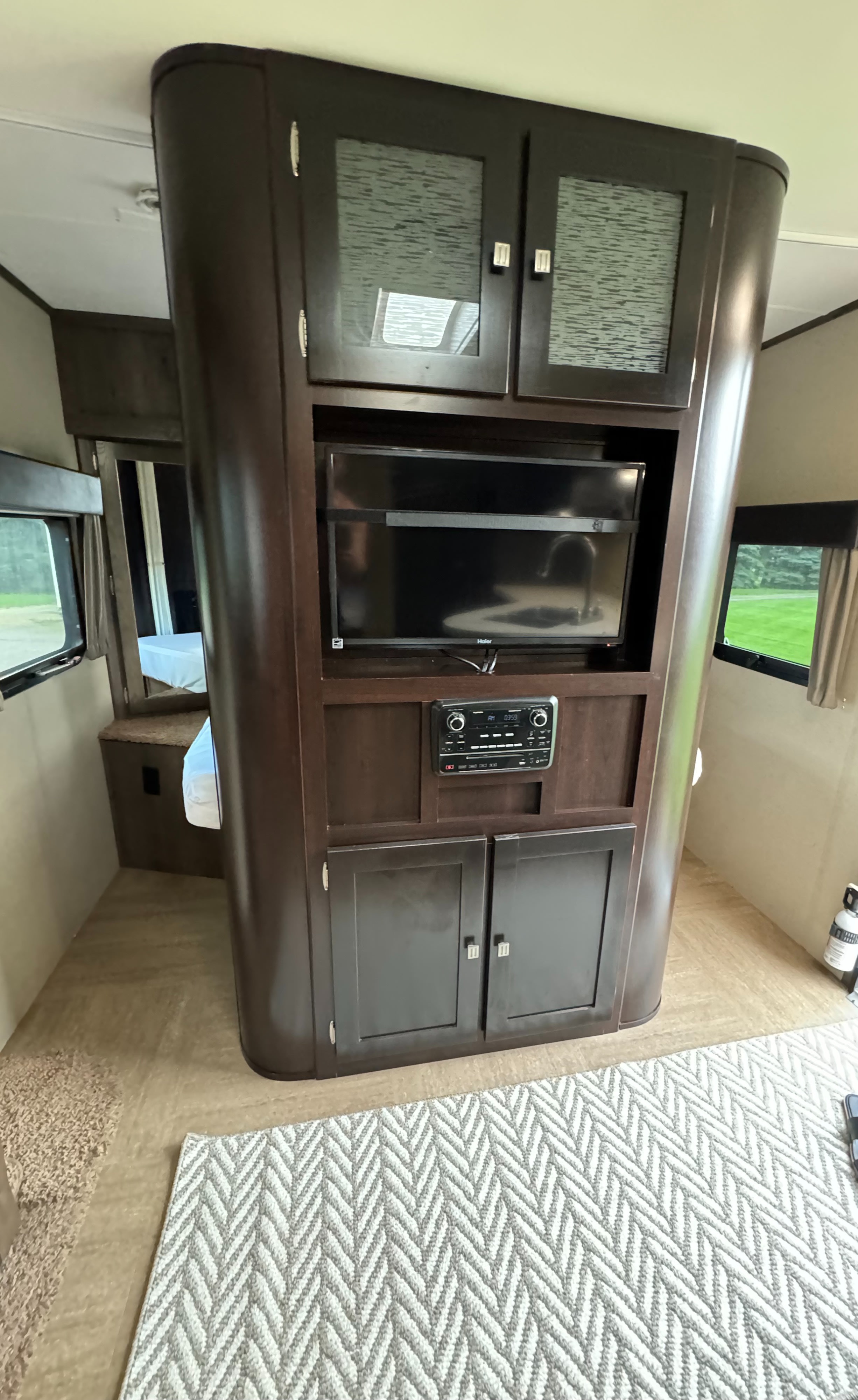 Step inside this rv rental to find a central dark wood entertainment unit with TV, stereo, storage, and a glimpse of the bedroom.. Dutchmen Kodiak 2015