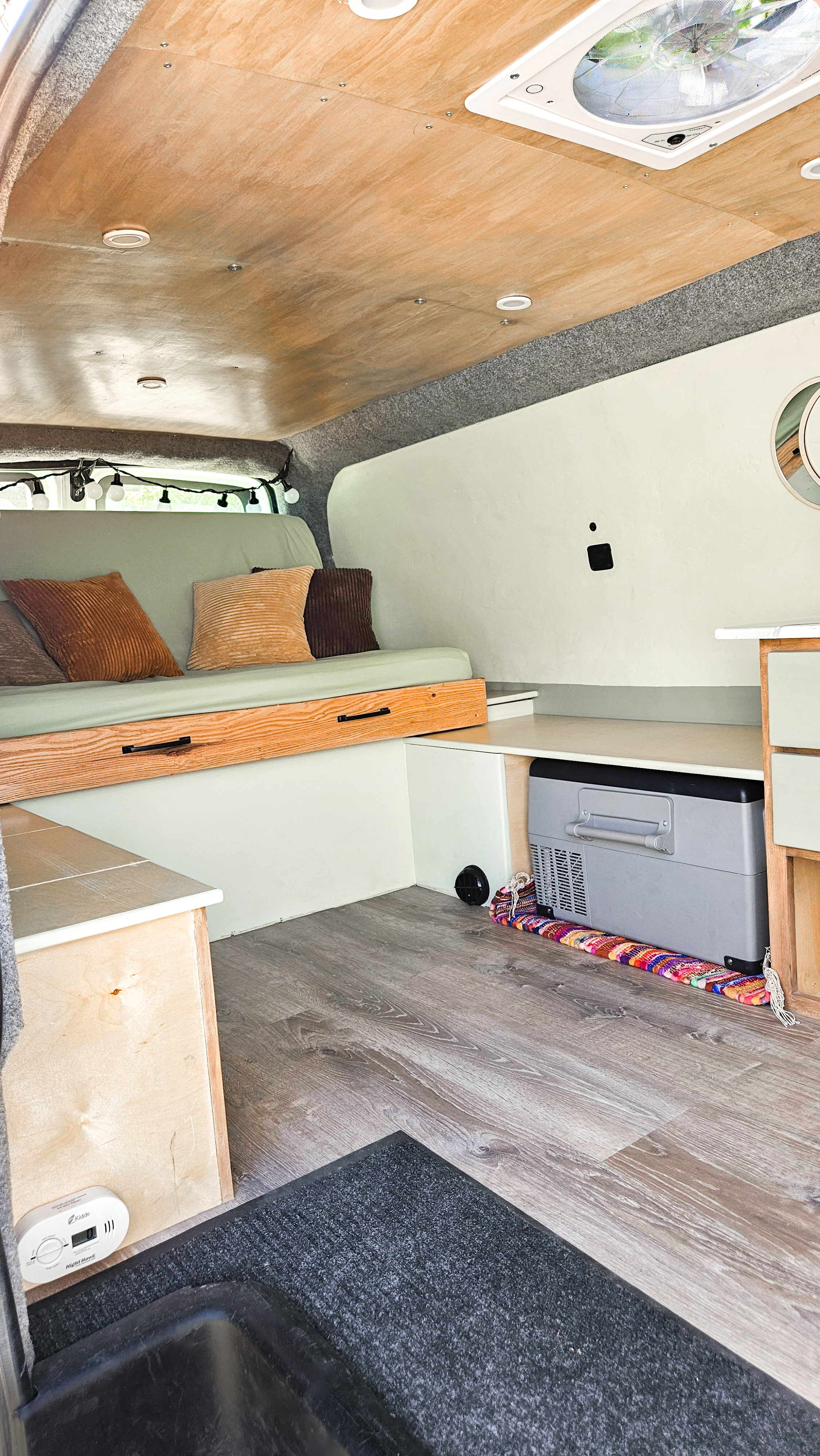 RV rental interior: cozy camper van with bed, built-in storage, wood ceiling, and floor. Includes cooler.. Chevrolet Express 2500 camper 2015