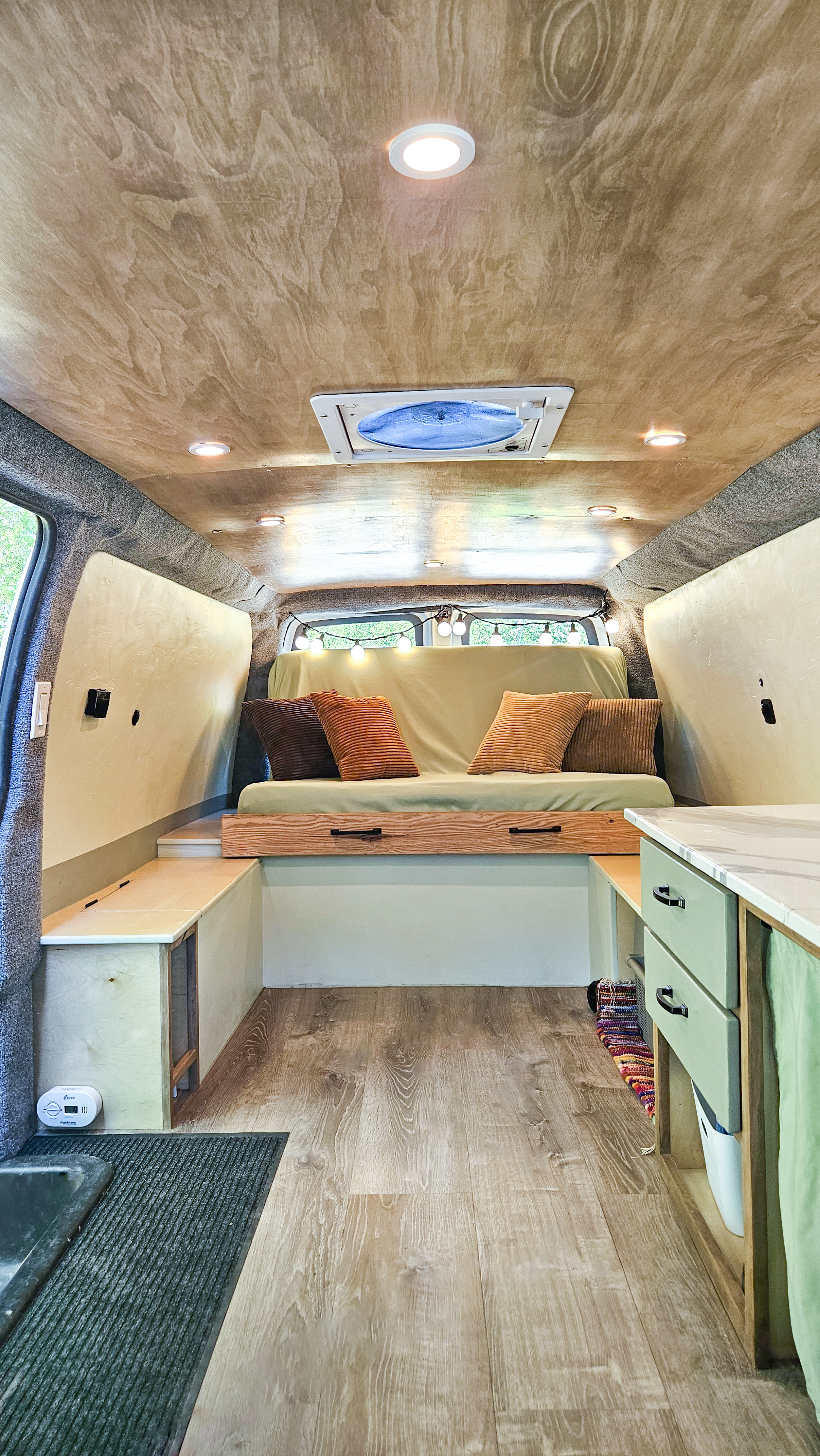 Cozy RV rental interior featuring a wood ceiling, recessed lights, comfy sofa, and practical built-in storage.. Chevrolet Express 2500 camper 2015