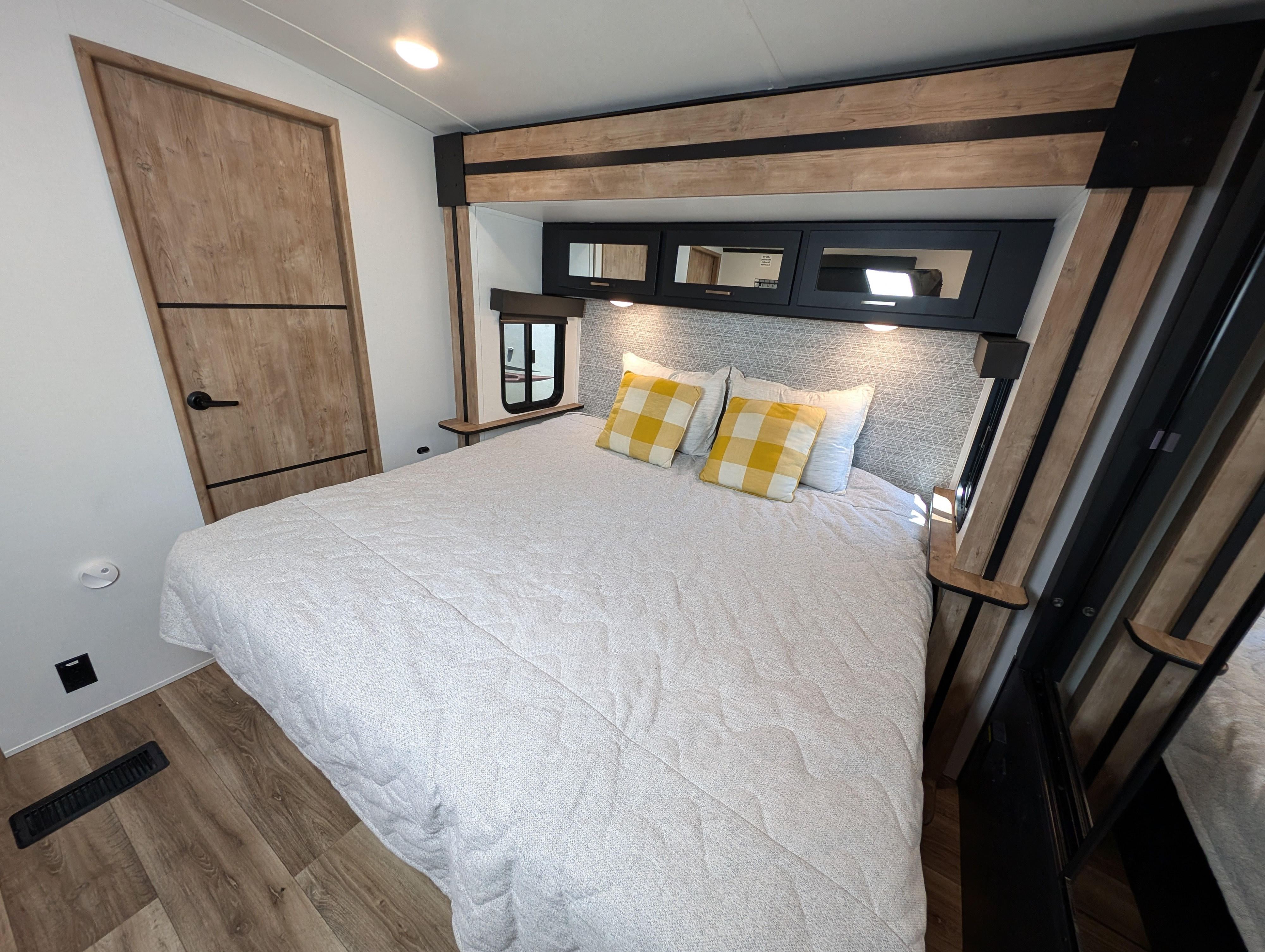 Spacious and modern RV rental bedroom with a comfortable bed, overhead storage, and stylish decor, perfect for your next road trip.. Keystone Outback 2023