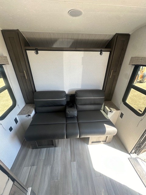 RV rental interior featuring a versatile convertible couch and bed system, large windows, and wood-look flooring.. Viking SAGA 17FQS 2022