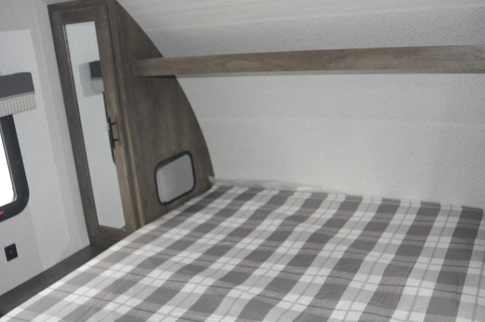 Master bedroom with two small closets with AC plug for charging phones or using CPAP machines and overhead shelf. Additional storage under bed end. . Door separates bedroom for privacy. Includes a 20" smart TV.. Forest River Salem Cruise Lite 2022