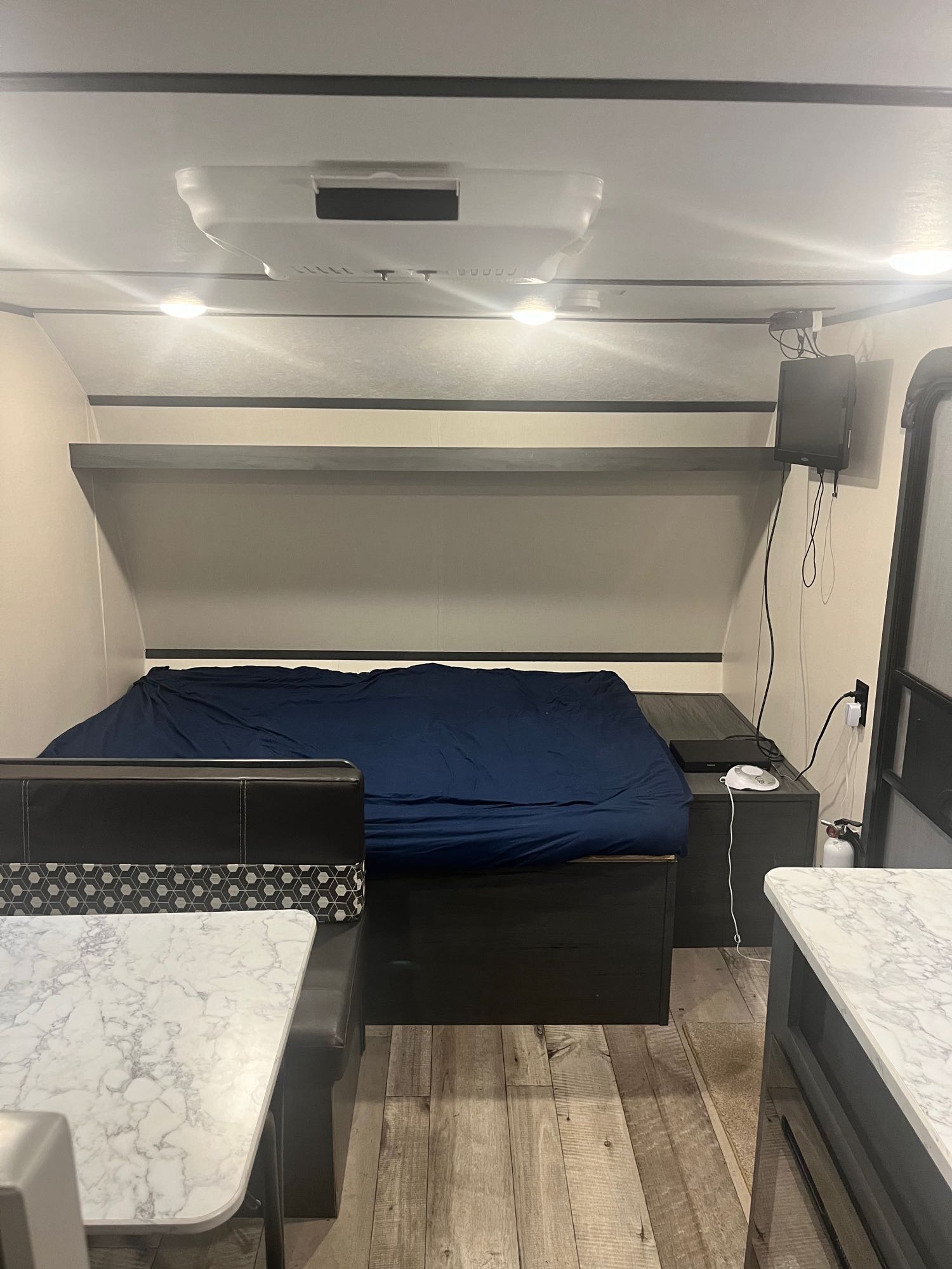 Inside an rv rental: a compact living space featuring a bed, dinette, small TV, and overhead AC unit.. Aspen Trail LE 2021