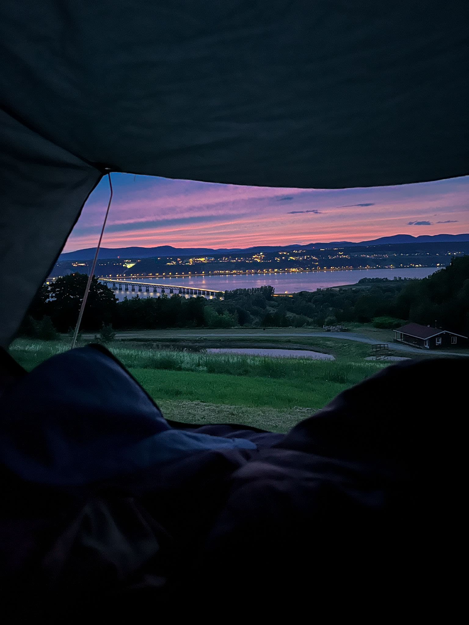 RV rental view: stunning sunset over a lit bridge, lake, and distant city from a peaceful campsite.. Ford Escaper 2013