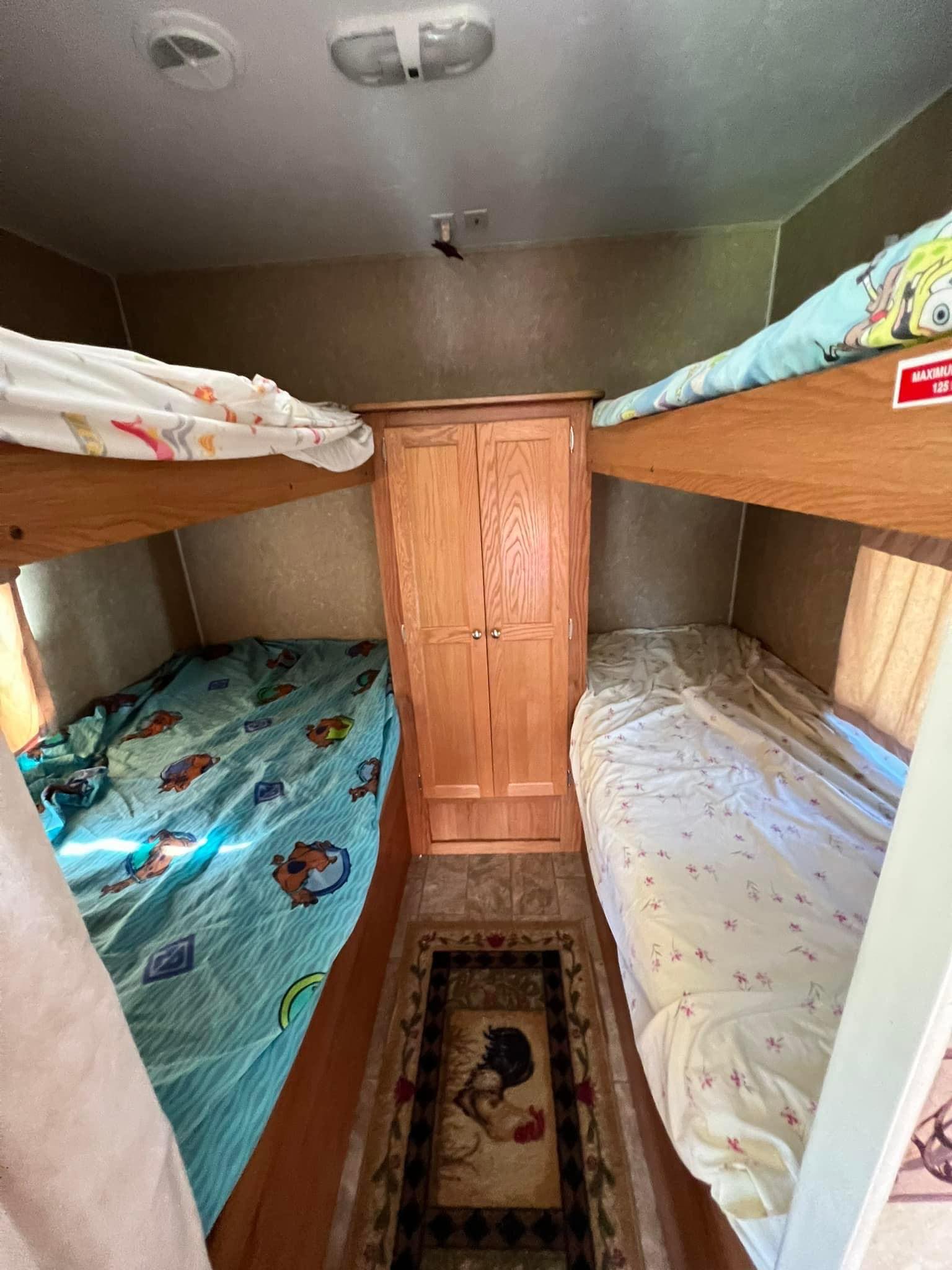 RV rental bunk beds. Cozy sleeping area in a camper with two sets of bunks, fun bedding & central cabinet. Max 125 lbs.. Gulf Stream Trailmaster 2009
