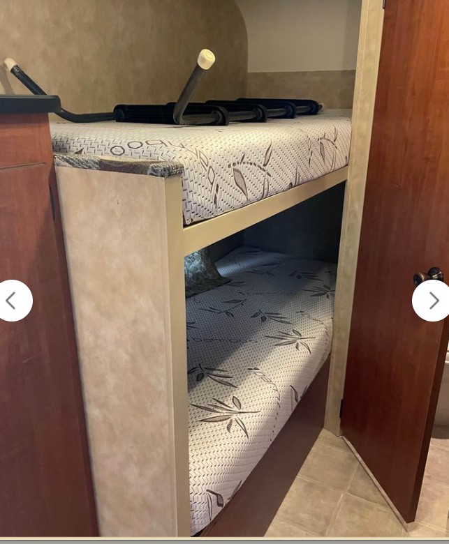 Comfortable bunk beds for your RV rental adventure! Two mattresses with a leaf pattern provide cozy sleeping in this RV interior.. Sportsmen Sportsmen Trailer 2011