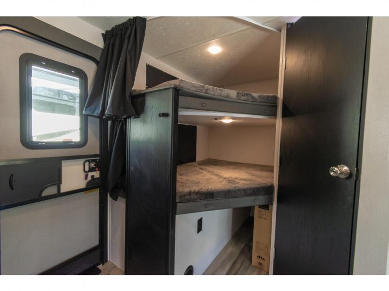 RV rental interior showcases compact bunk beds, storage, and an entry door for convenient family trips.. Coachmen Freedom Express 2022