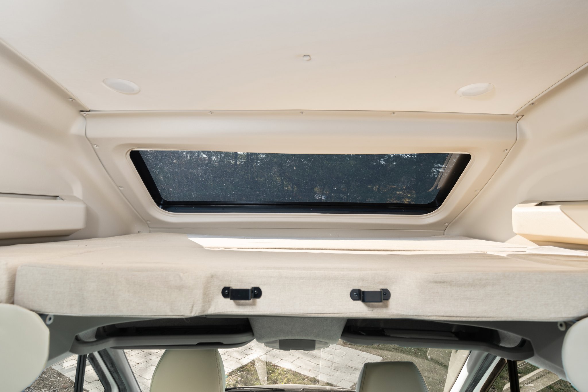 Inside an RV rental: a cozy cab-over bunk bed with a bright skylight above, perfect for a comfortable night's sleep.. Entegra Coach Qwest 2018