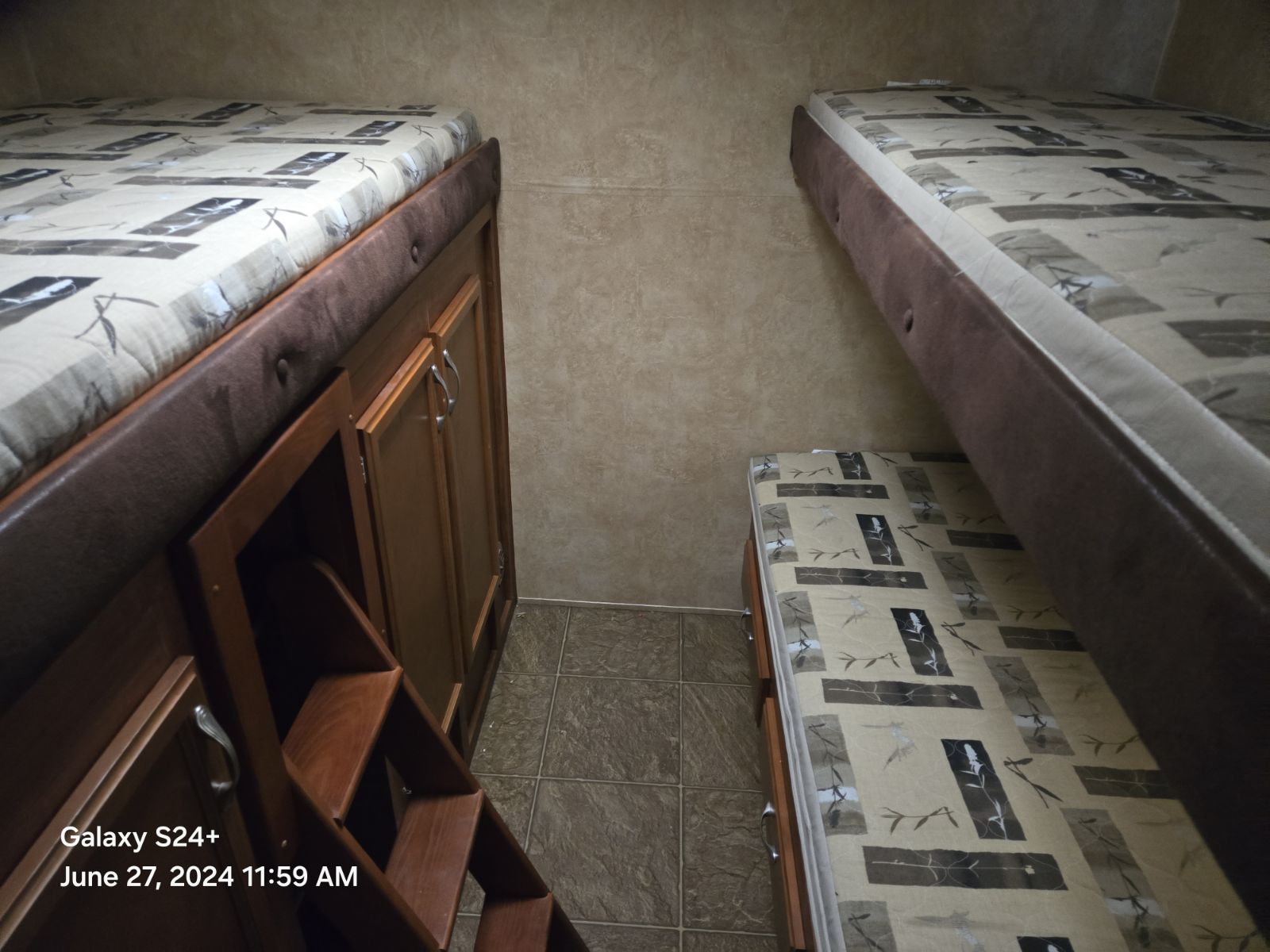 Compact RV rental sleeping area featuring three bunk beds, built-in storage, and a small ladder for access.. Jayco Eagle Super Lite 2011