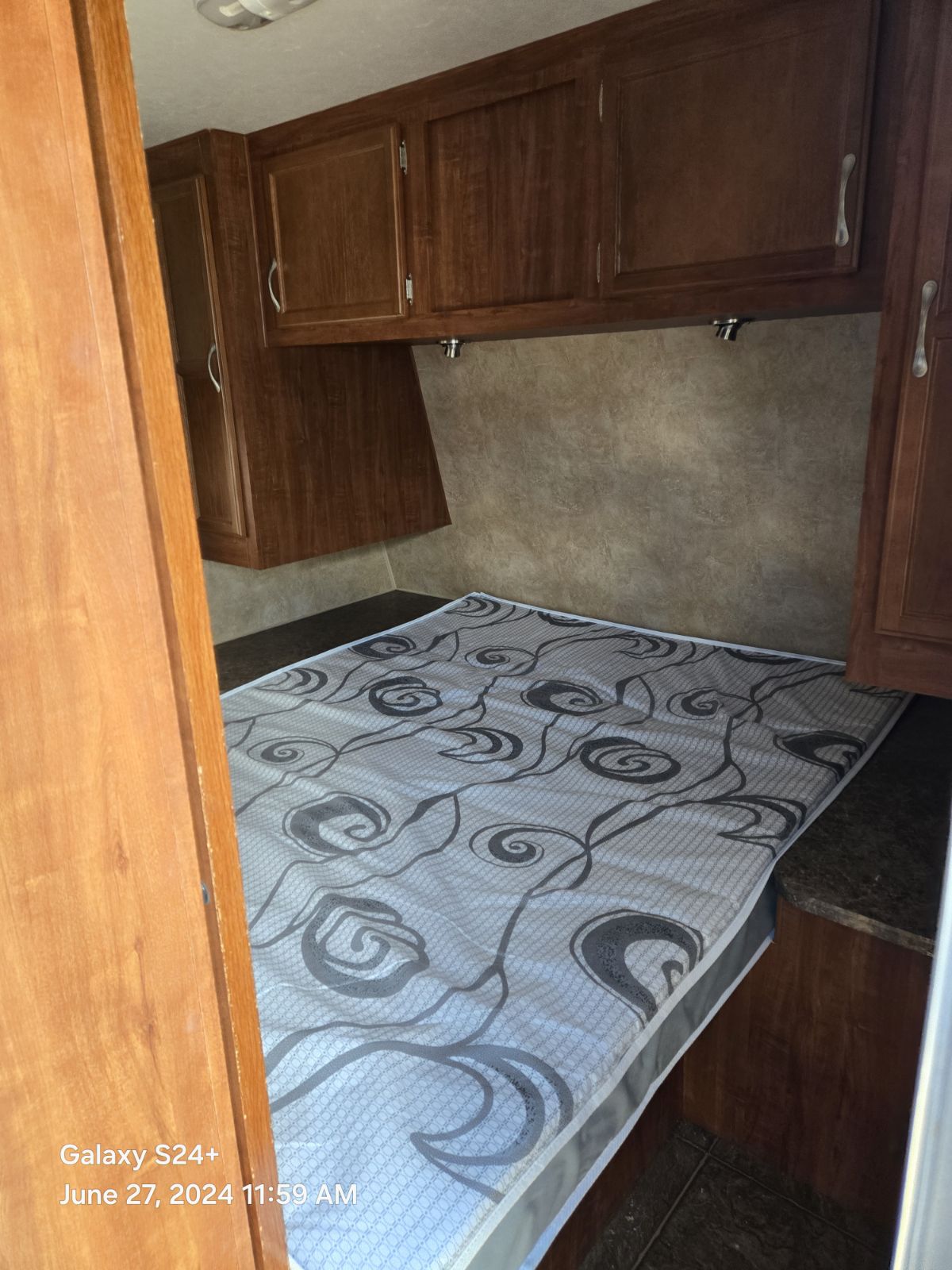 RV rental bedroom: Cozy space with patterned bed, wood cabinets, & lighting.. Jayco Eagle Super Lite 2011