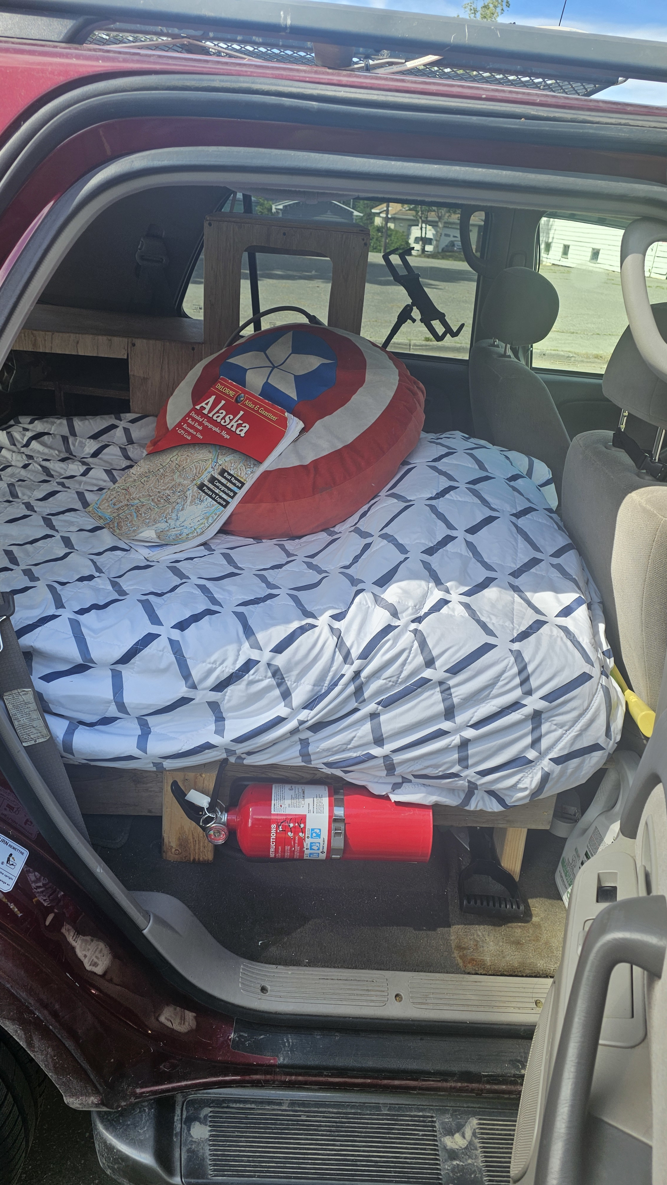 This DIY camper conversion for an RV rental features a bed, Captain America pillow, Alaska map, and fire extinguisher for safe travel.. Rv Camper Sequoia 2003