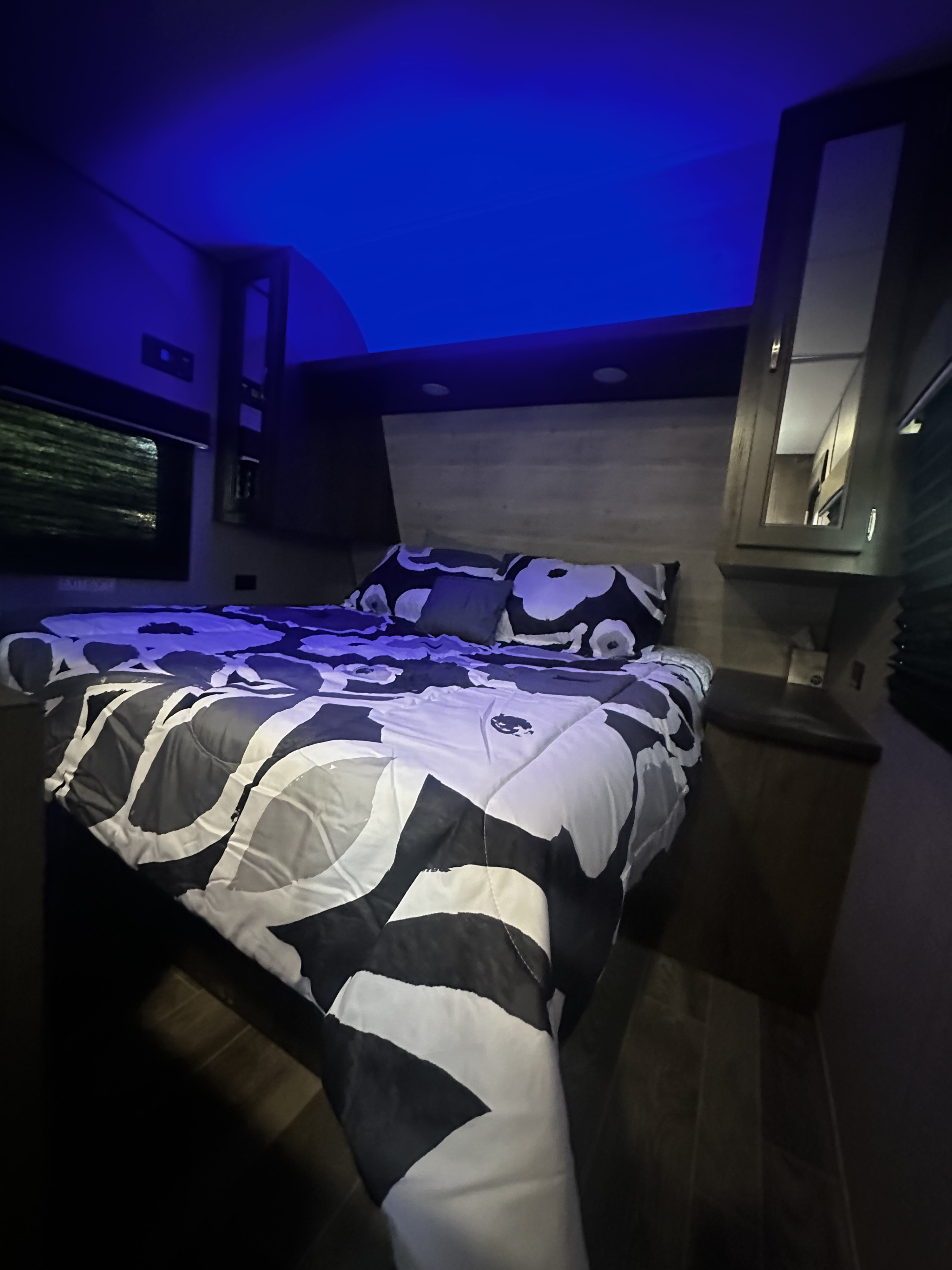 Experience comfort in this RV rental bedroom: modern bedding, clever storage, and blue mood lighting.. Jayco Jay Flight SLX Baja Edition 2021
