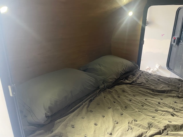 RV rental interior: A cozy sleeping space features a comfortable bed with pillows and warm lighting.. Custom Built Teardrop 2014