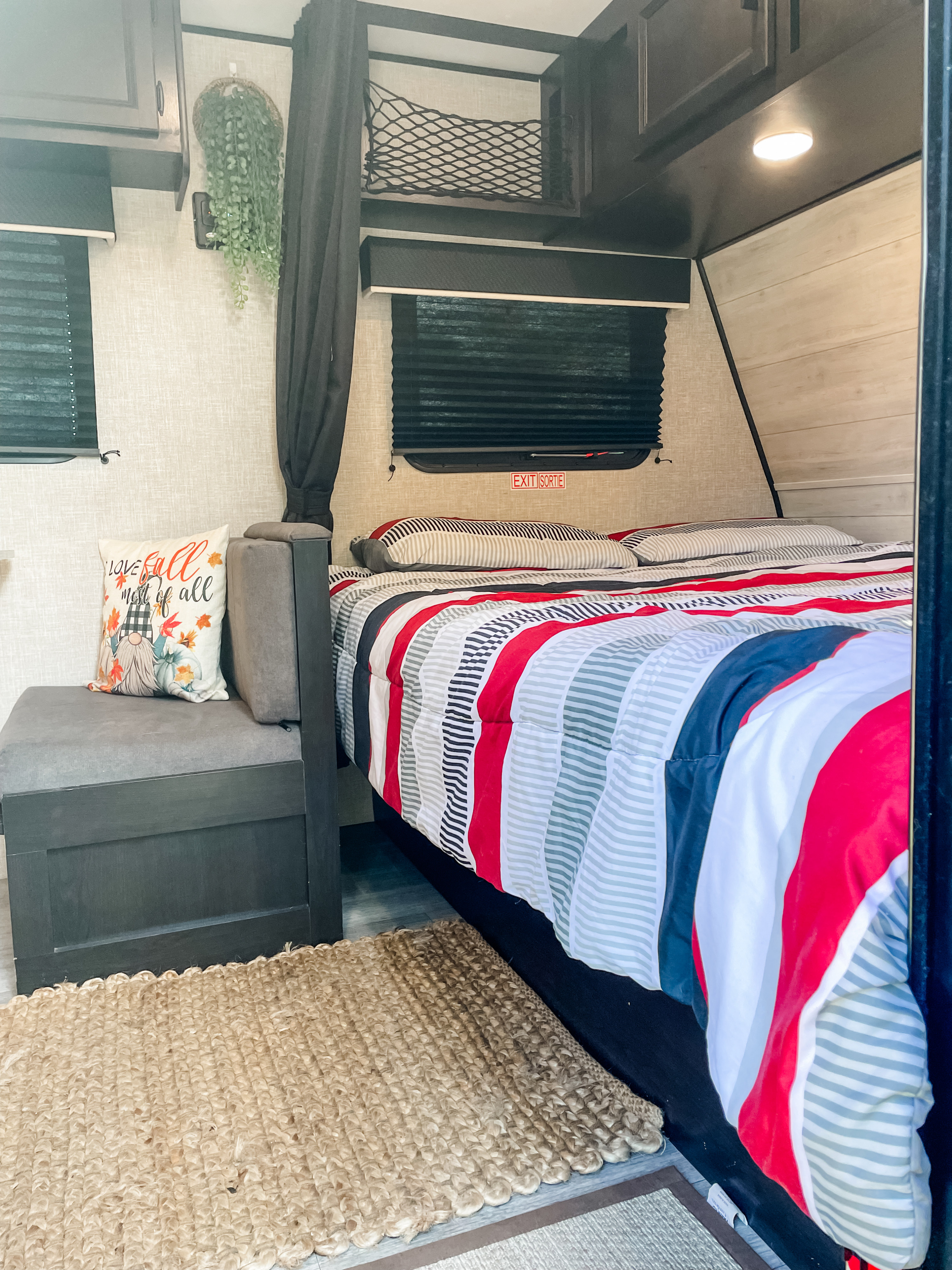 Cozy RV rental interior featuring a striped bed, seating with a fall pillow, and practical overhead storage.. Jayco Jay Flight SLX Baja Edition 2022