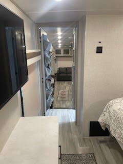 Inside a bright RV rental: view from the bedroom past bunks into a cozy living space.. Forest River Rockwood Ultra Lite 2022