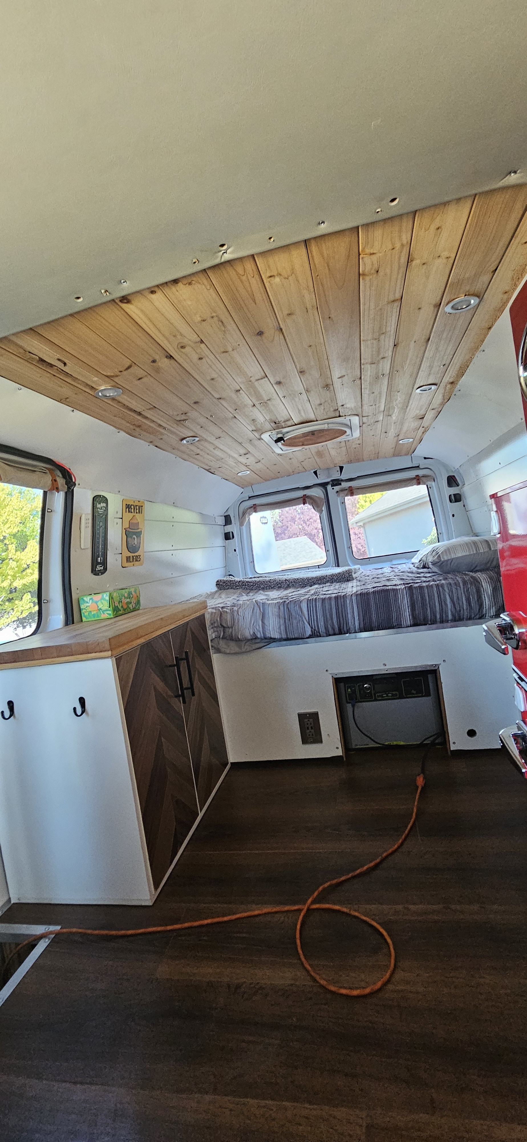 Tour this RV rental's interior: a cedar plank ceiling, cozy bed, and custom cabinets with a power system.. Ford Econolline 250s 2005