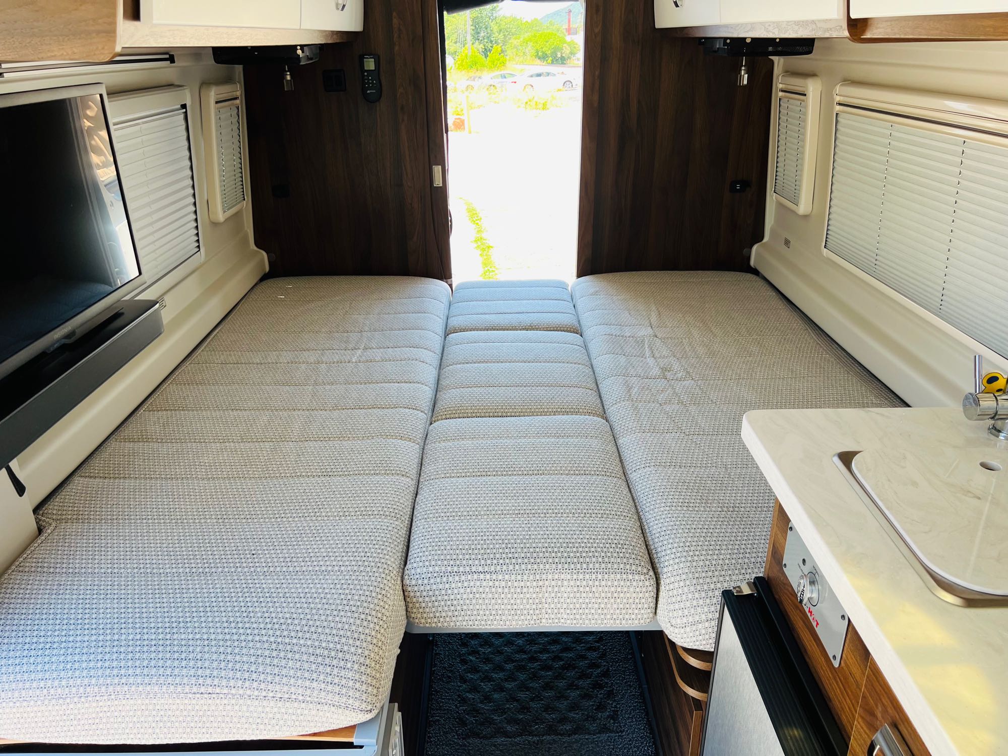 RV rental: Bright interior with convertible beds, TV, and kitchen area. Perfect camper for adventures.. Winnebago Travato 2023