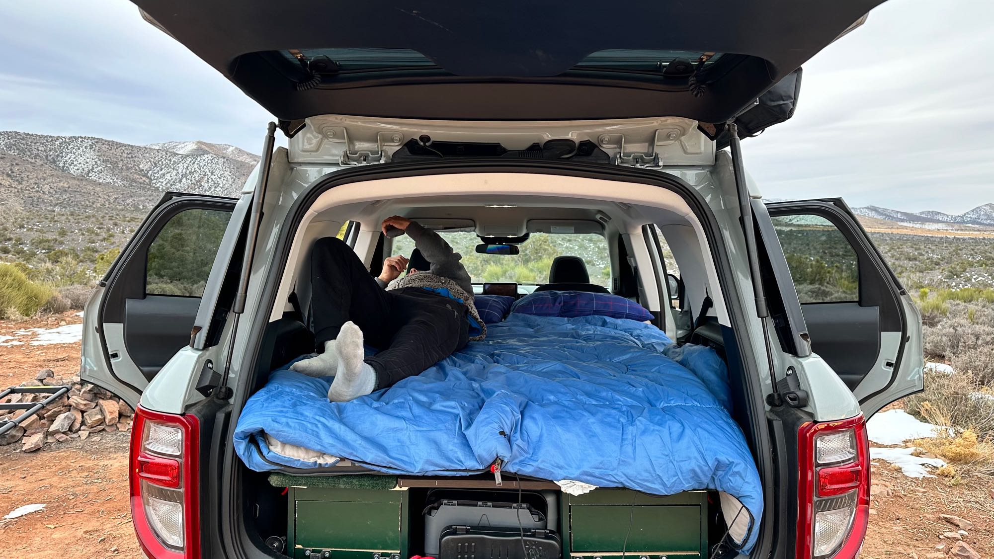 Cozy car camping setup inside an SUV, offering comfort for mountain road trips like an RV rental.. Ford Bronco Sport 2022