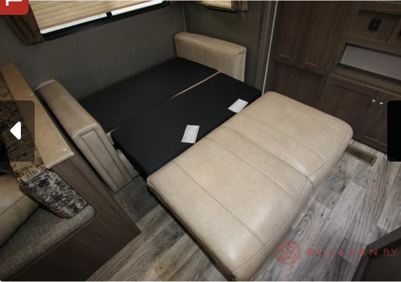 RV rental: Beige RV sofa converting to a black bed, revealing a compact and versatile living space for travelers.. Keystone RV Hideout 2019