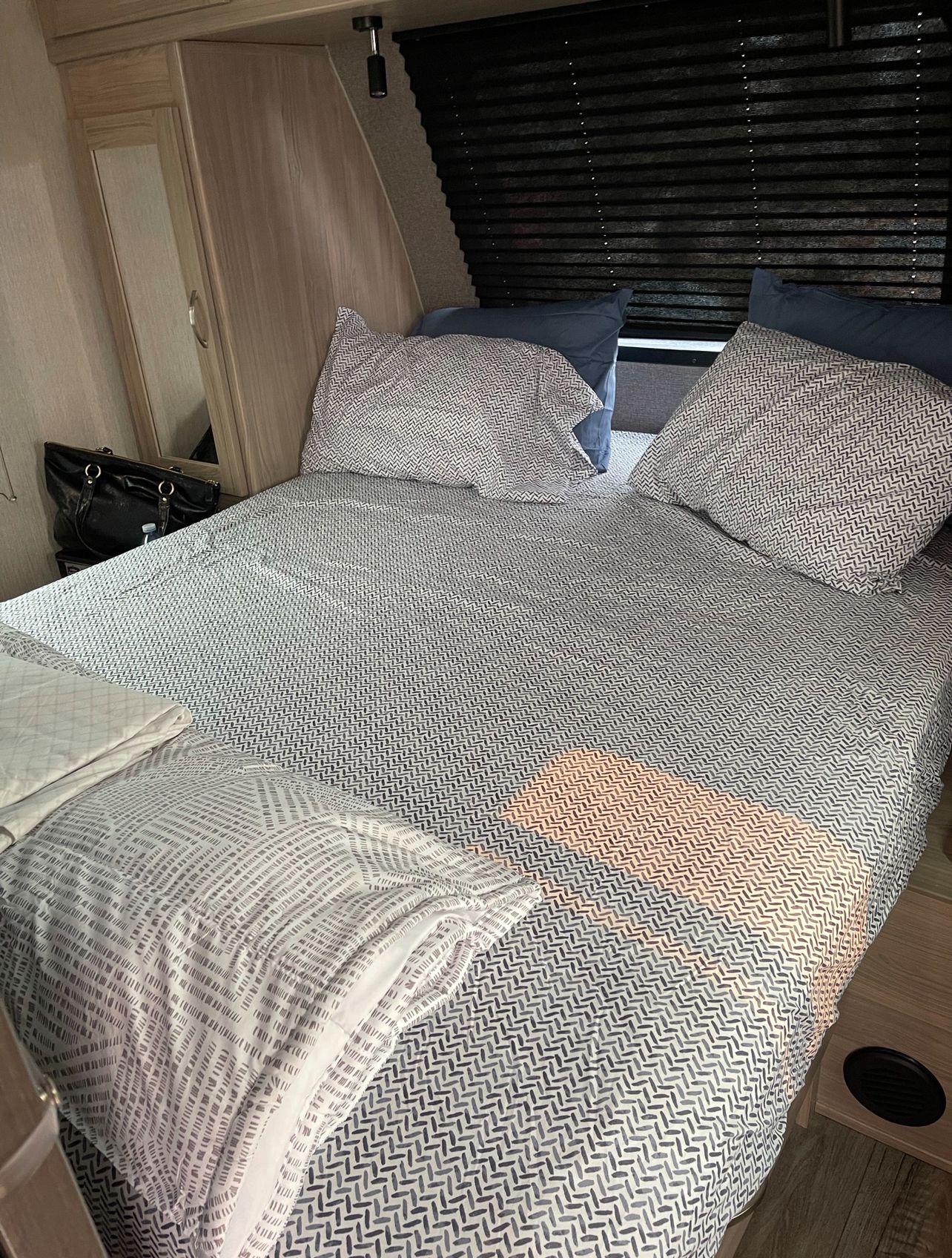 RV rental bedroom with a comfy bed, patterned linens & blue pillows, plus storage. Ideal for restful sleep on your journey.. Coachmen fet257bhs-320 2021