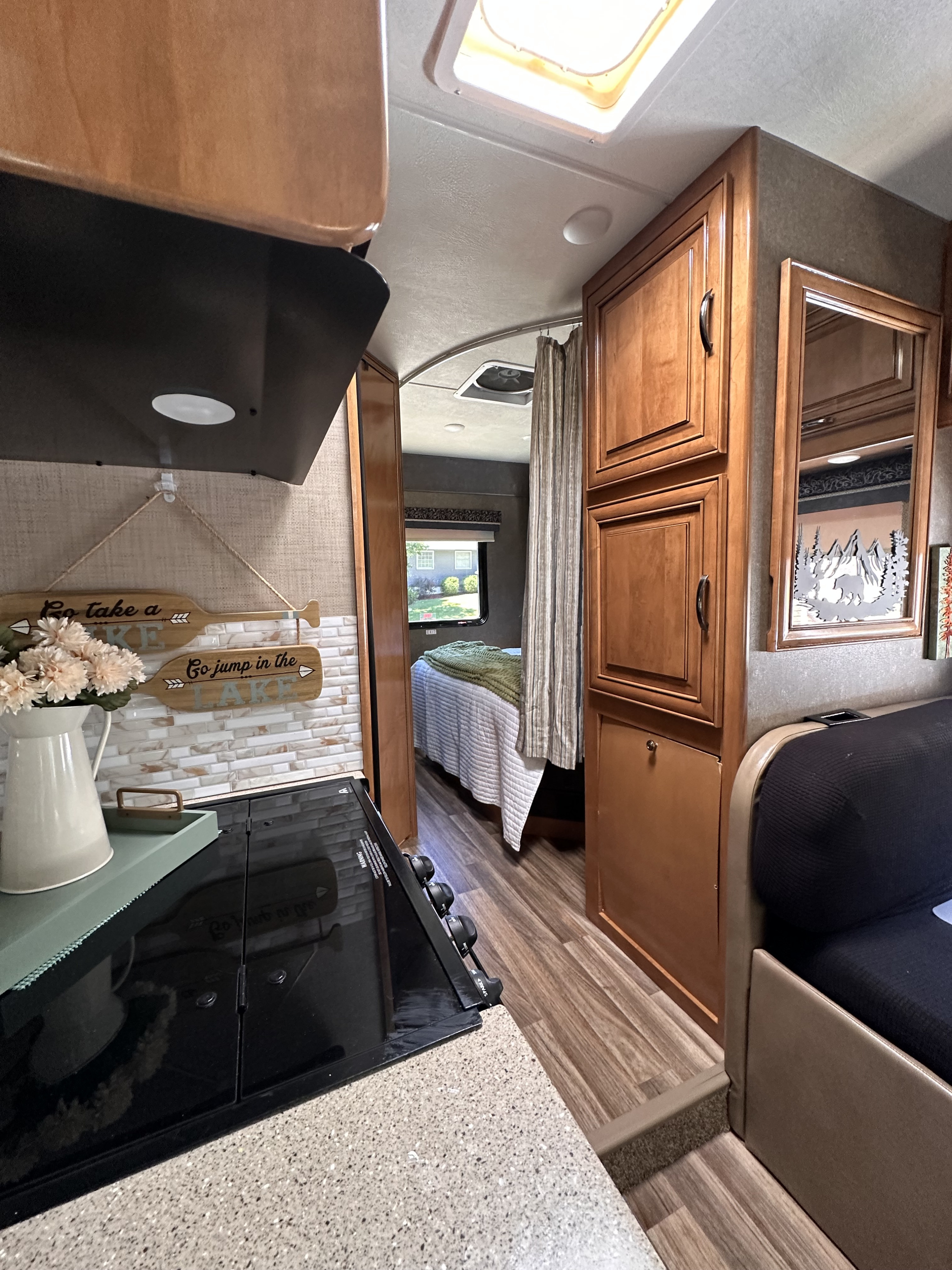 Cozy RV rental interior showcasing a kitchen, hallway to the bedroom, and comfortable living space, ready for your next adventure.. Thor Quantum 2018