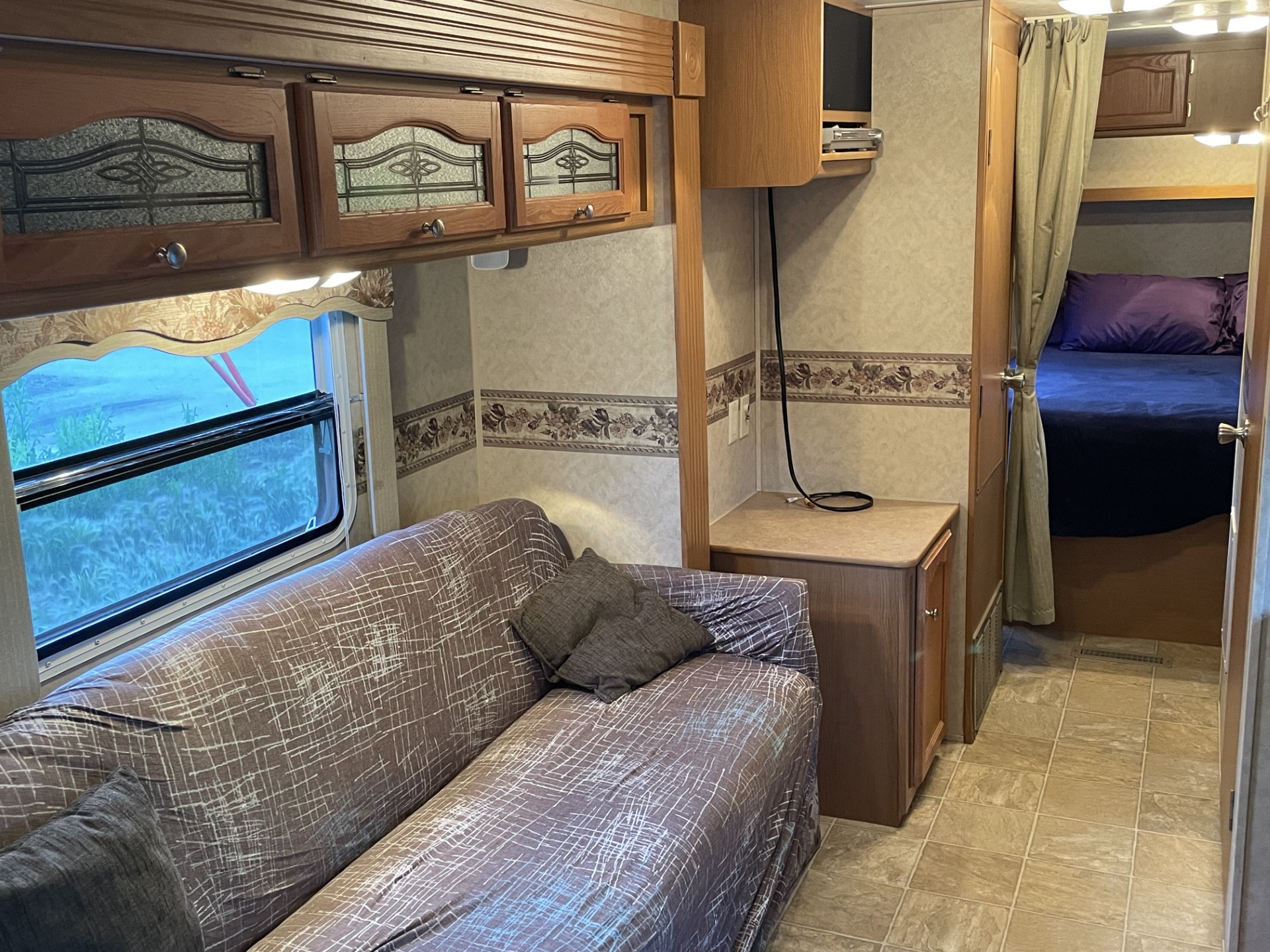 Experience comfort in this RV rental featuring a sofa, ornate cabinets, an entertainment area, and a cozy bedroom.. Dutchmen Dutchmen 2007