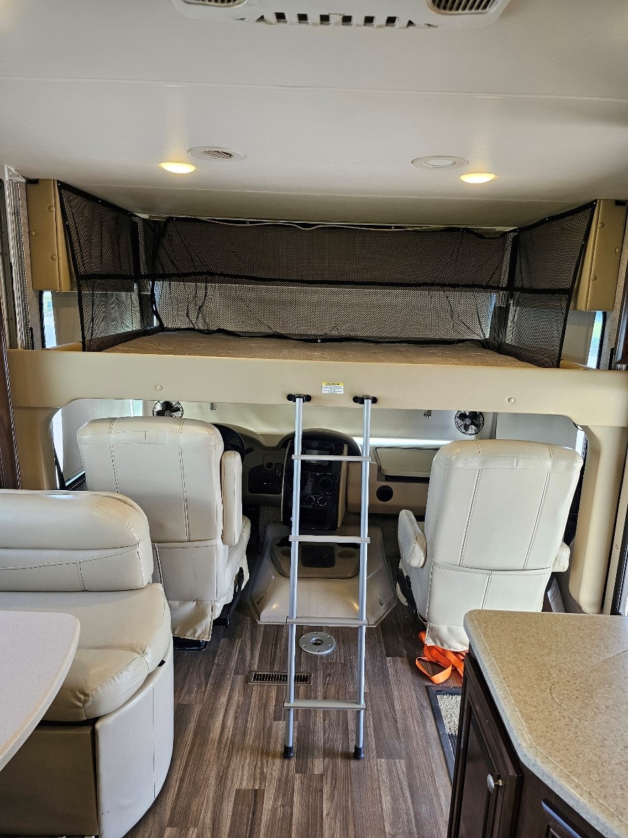 Step inside this RV rental: front cab, overhead bunk with net, ladder, and cozy living space.. Thor Miramar 2017
