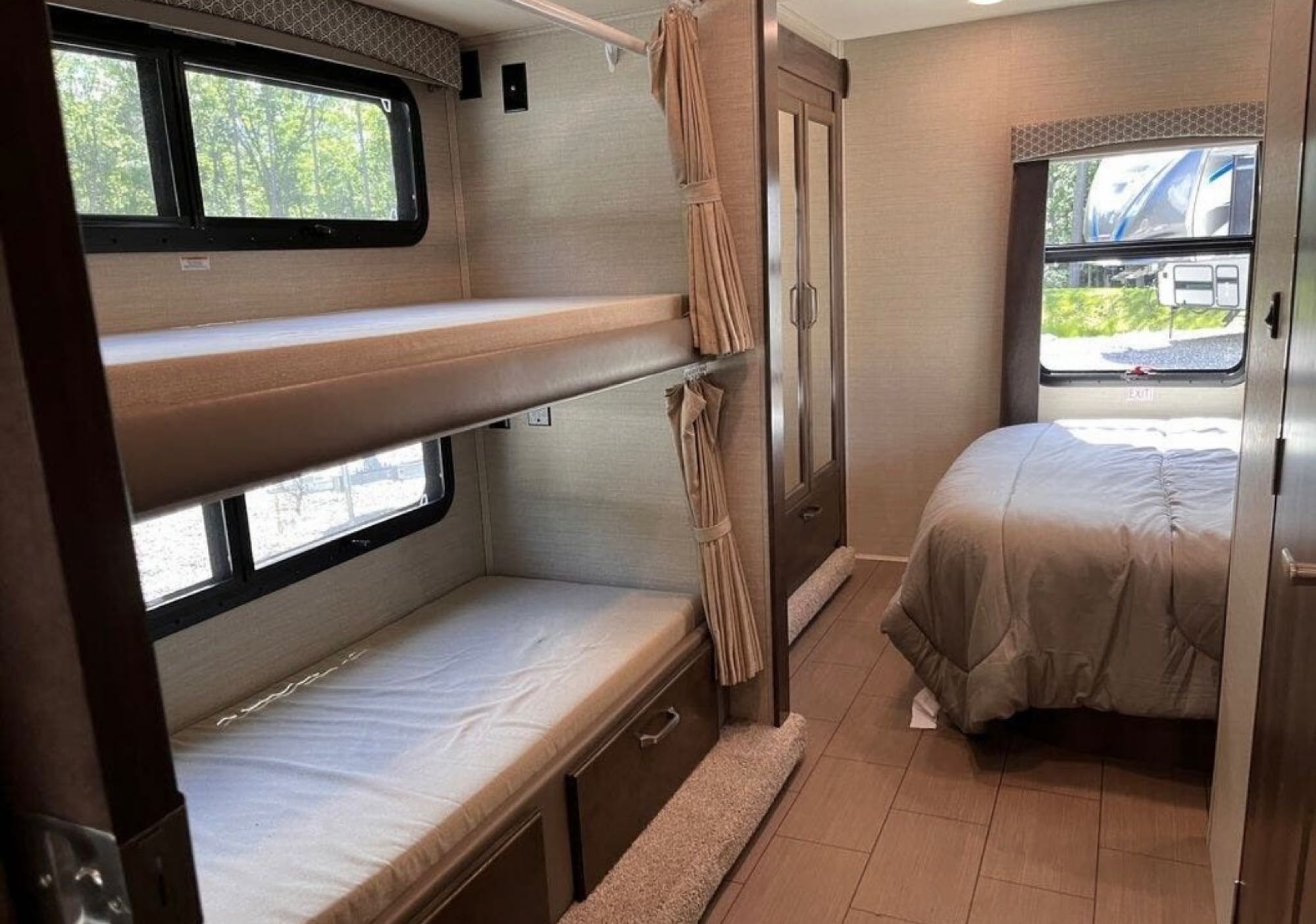 Inside an RV rental: features cozy bunk beds, a private master bedroom, and storage, perfect for family travel.. Jayco Greyhawk 2018