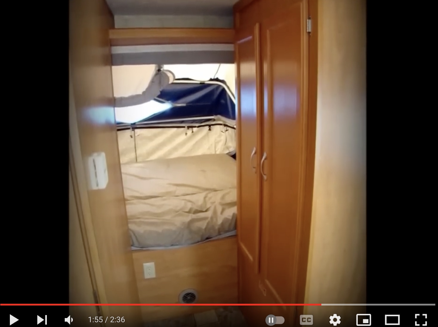 RV rental bedroom with a cozy pop-up canvas bed, built-in wooden wardrobe, and control panel visible. Ideal for camper travel.. Dutchmen Kodiak Ultra Lite with 2 pop-up 2009
