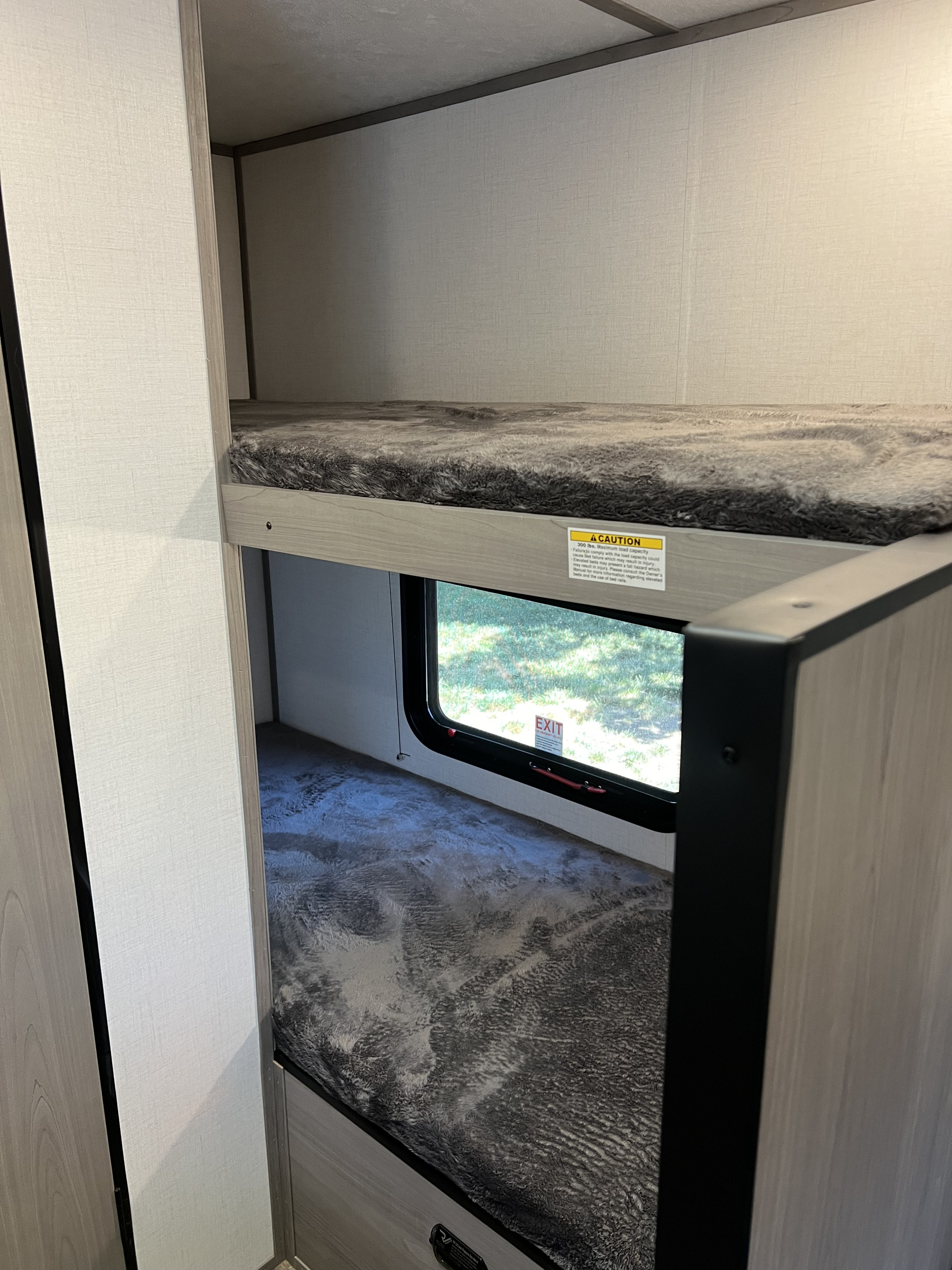 RV rental: Functional bunk beds within a compact interior, featuring an emergency exit window for safety.. Dutchmen Coleman Lantern LT 17B 2024