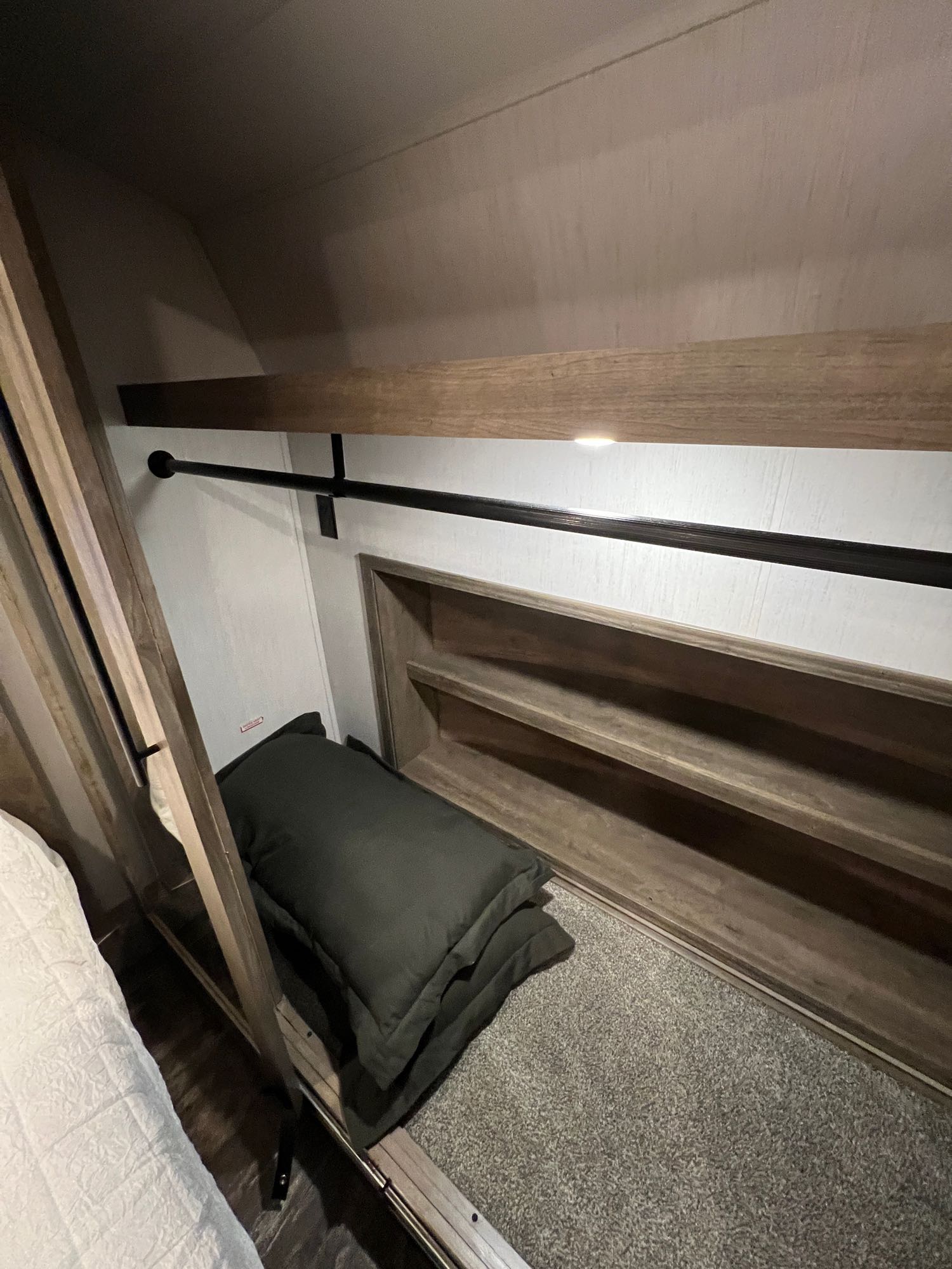 RV rental bedroom closet featuring a hanging rod, built-in shelves, & storage for compact living.. Forest River Sabre 2022