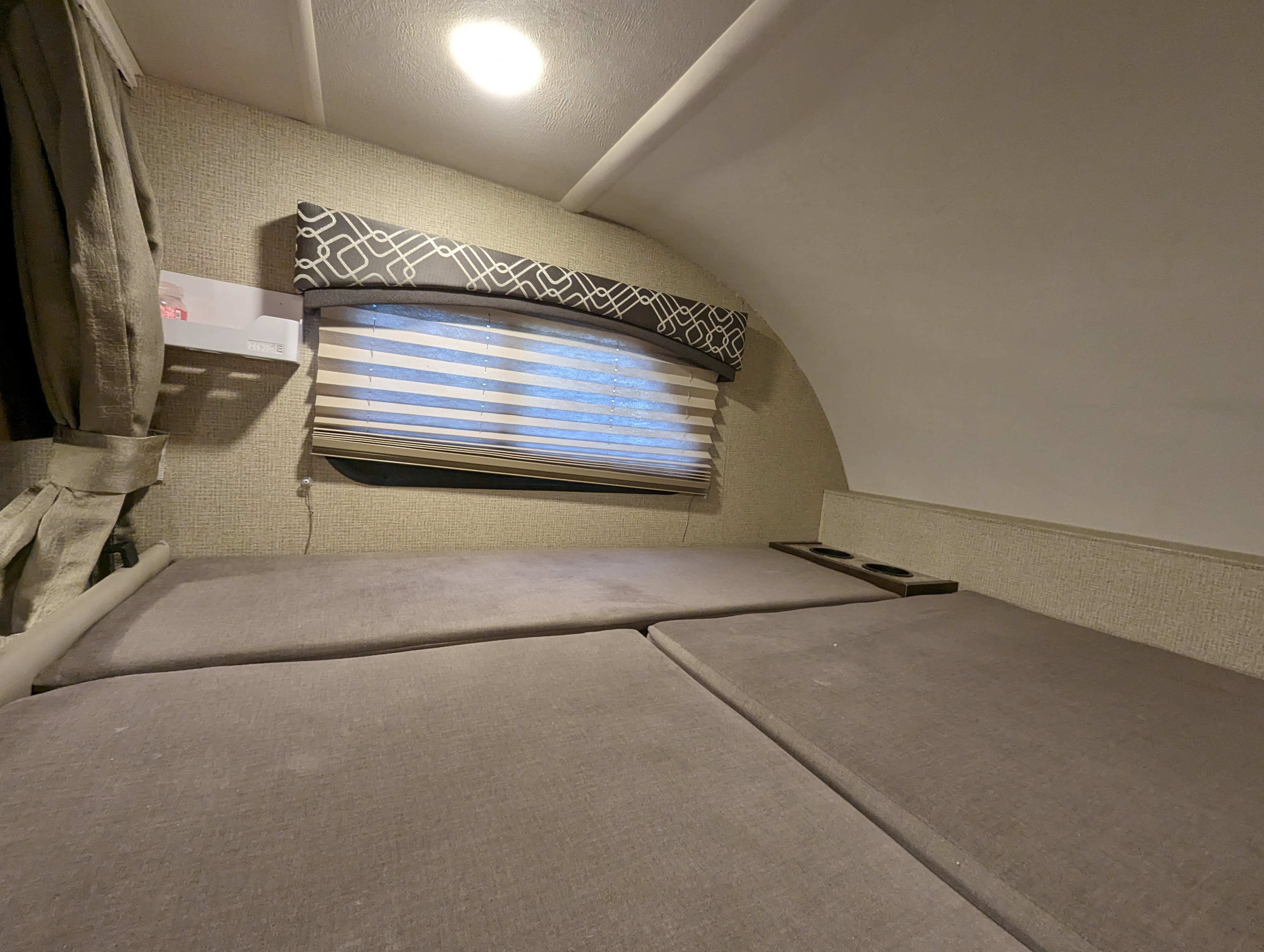 RV rental interior: A cozy bunk area with soft cushions, window blinds, and convenient cup holders.. Thor Chateau 2019