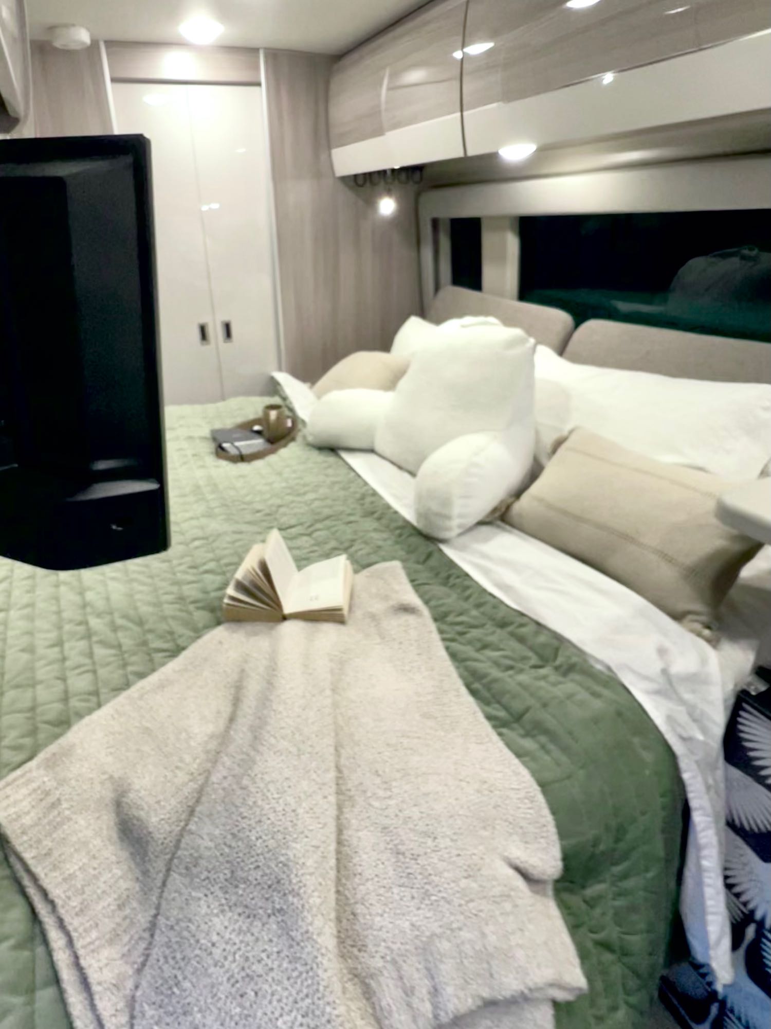Relax in this cozy RV rental bedroom with a quilted bed, TV, and overhead storage for your journey.. Thor Sequence 2023