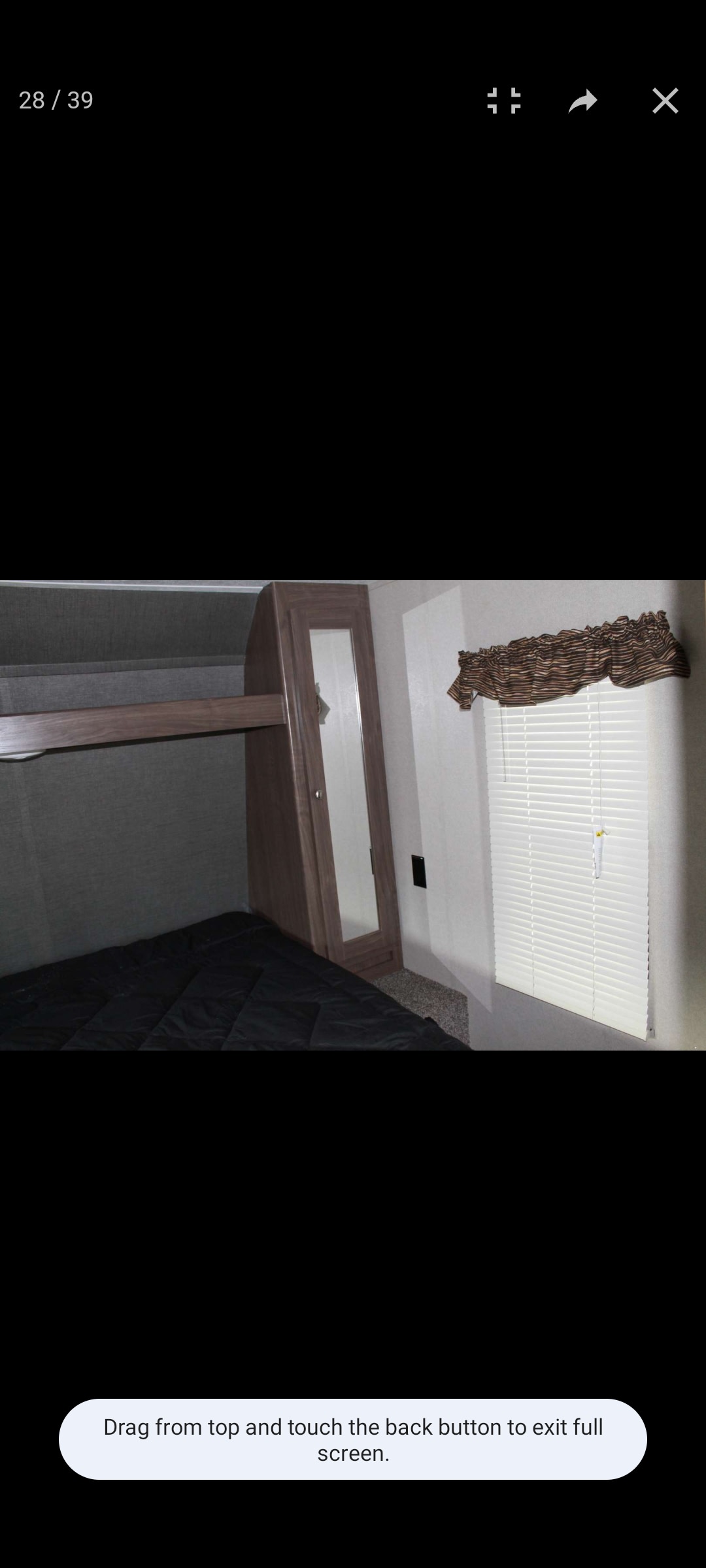 RV rental interior: a compact bedroom with a comfortable bed, built-in mirrored wardrobe, and window with blinds.. Keystone RV Hideout LHS 2018