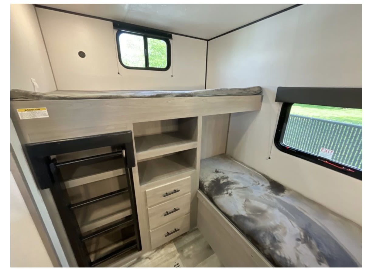 RV rental bunk room: upper and lower beds, ladder access, built-in shelving, & drawers. Perfect for families.. Dutchmen Coleman Lantern 2024