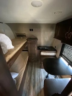 This cozy RV rental interior features bunk beds on the left and a dinette on the right, perfect for family adventures.. Jayco Jay Flight 2018