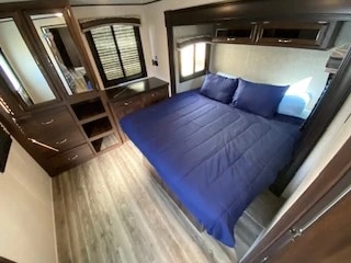 Comfortable RV rental bedroom with a large bed, overhead storage, and dresser. Your ideal mobile accommodation awaits.. Jayco Jay Flight 2018