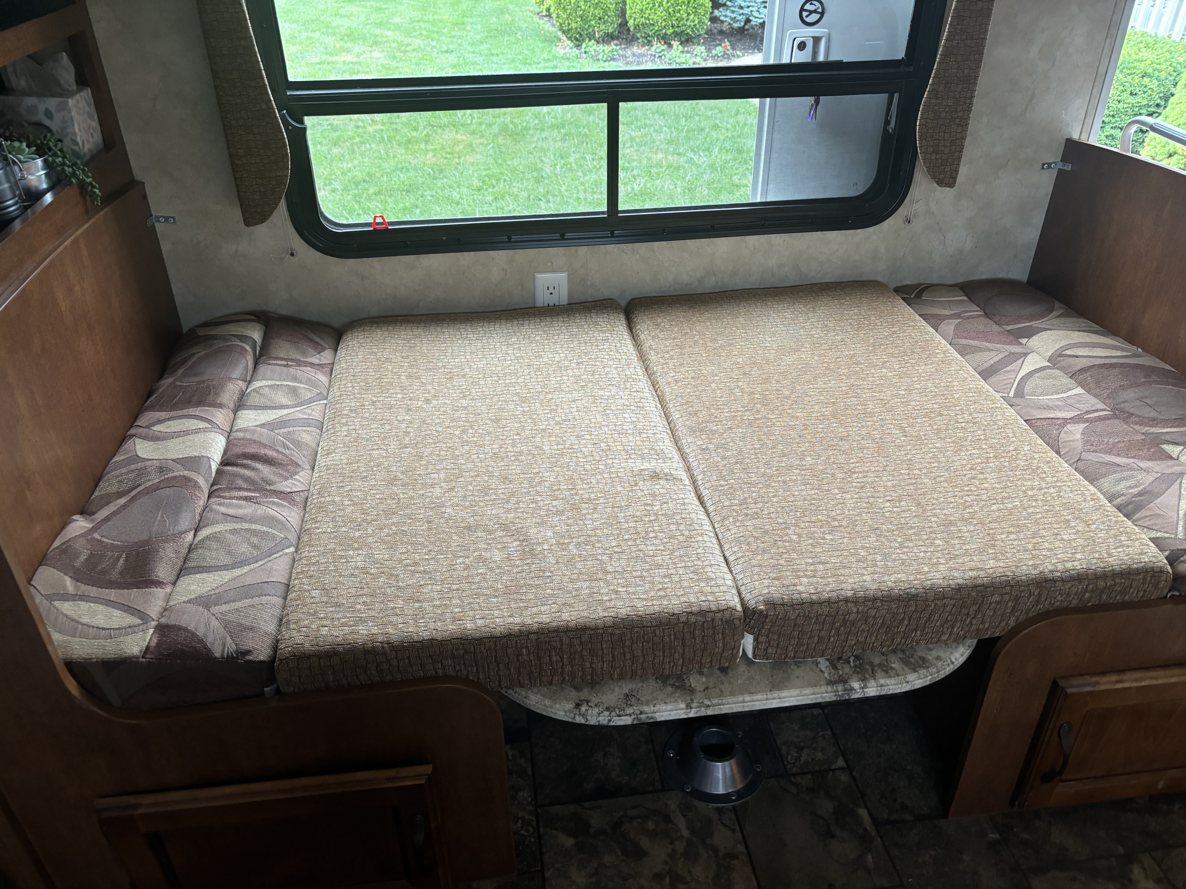 RV rental: Dinette area converted into a comfortable bed. Features two large upholstered cushions, a window, and wood cabinetry.. Coachmen Catalina Deluxe Edition 2013