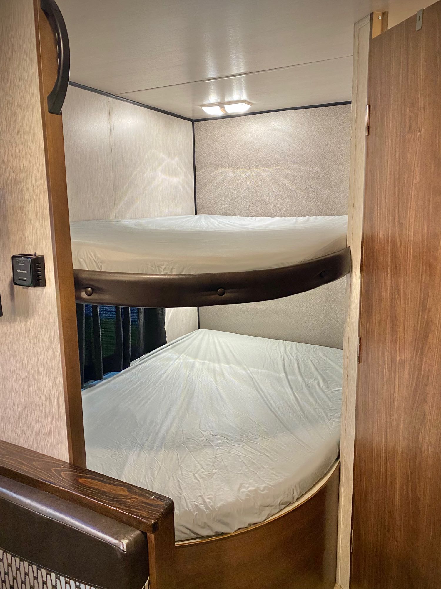 RV rental interior: two bunk beds with white sheets and a climate control panel for comfortable sleeping.. Heartland RVs Prowler Lynx 2018