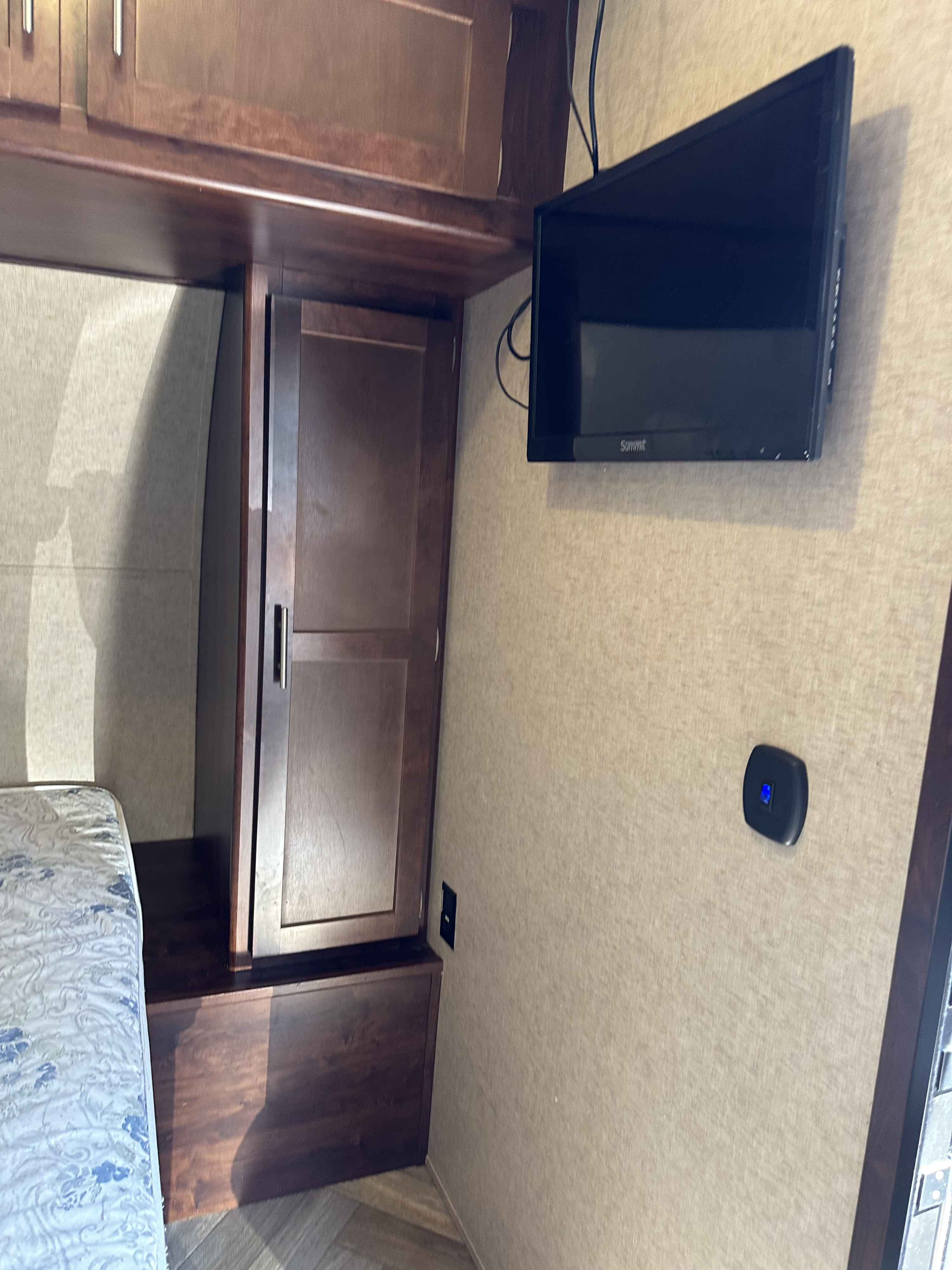 Discover this RV rental's bedroom: functional wood cabinets, a mounted TV, and convenient power outlets for comfort.. Forest River Vengeance Toy Hauler 2017