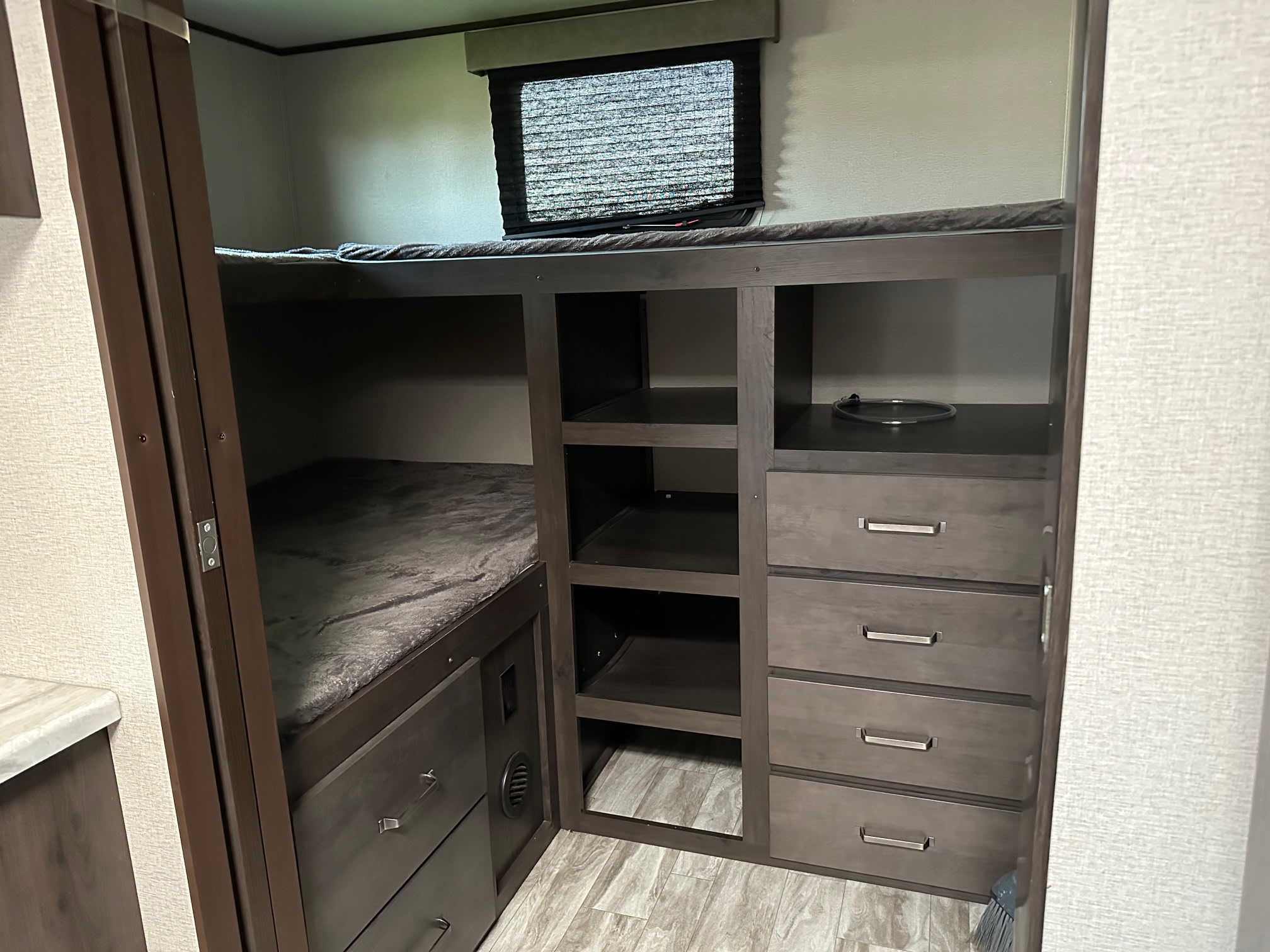 This RV rental features cozy bunk beds, built-in shelves, and drawers, offering efficient storage for travelers.. Grand Design Transcend 2020