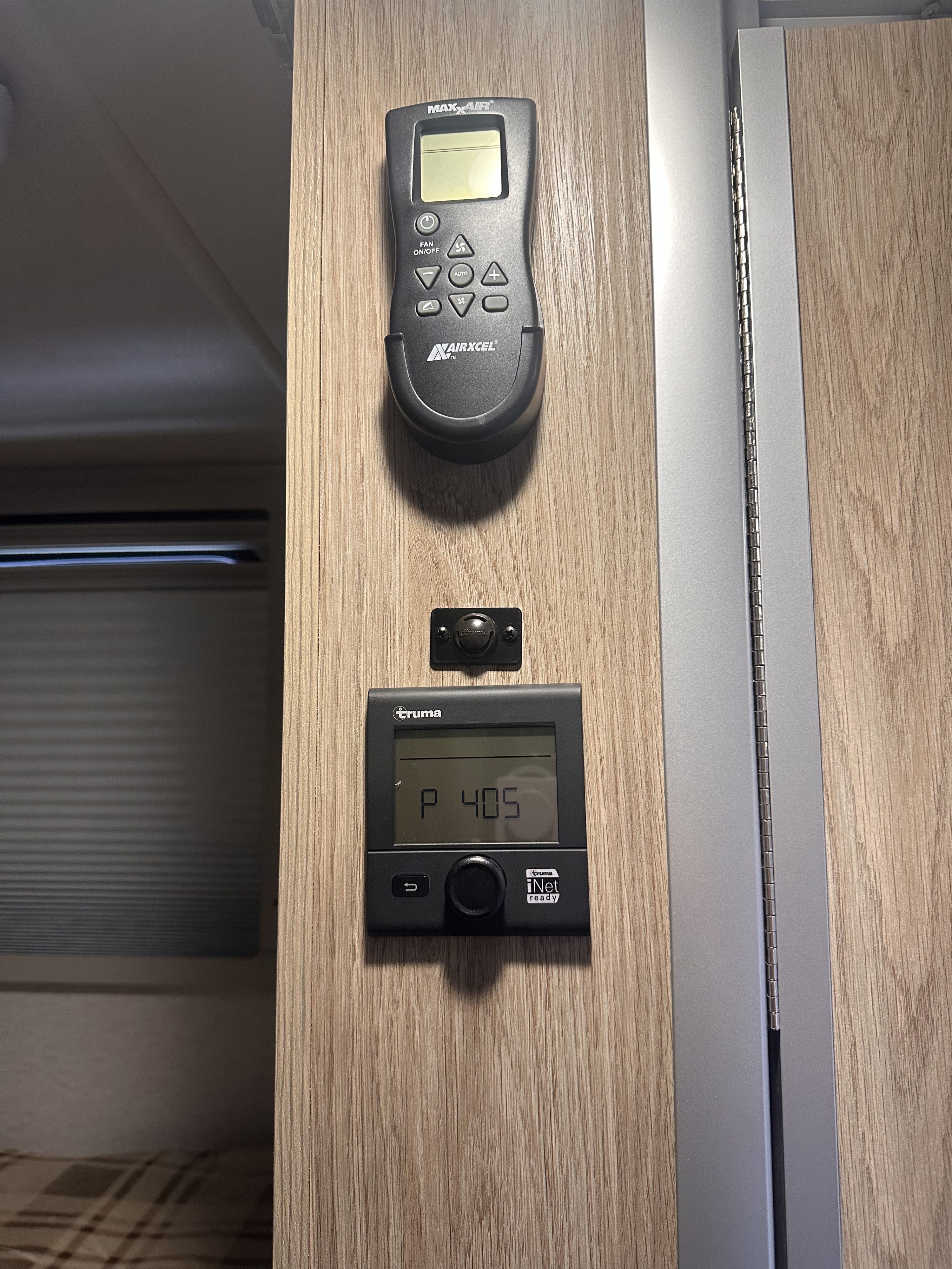 RV rental climate & heating controls: Airxcel MaxxAir remote & Truma iNet panel on wood wall, with sensor.. Winnebago Ekko 2025