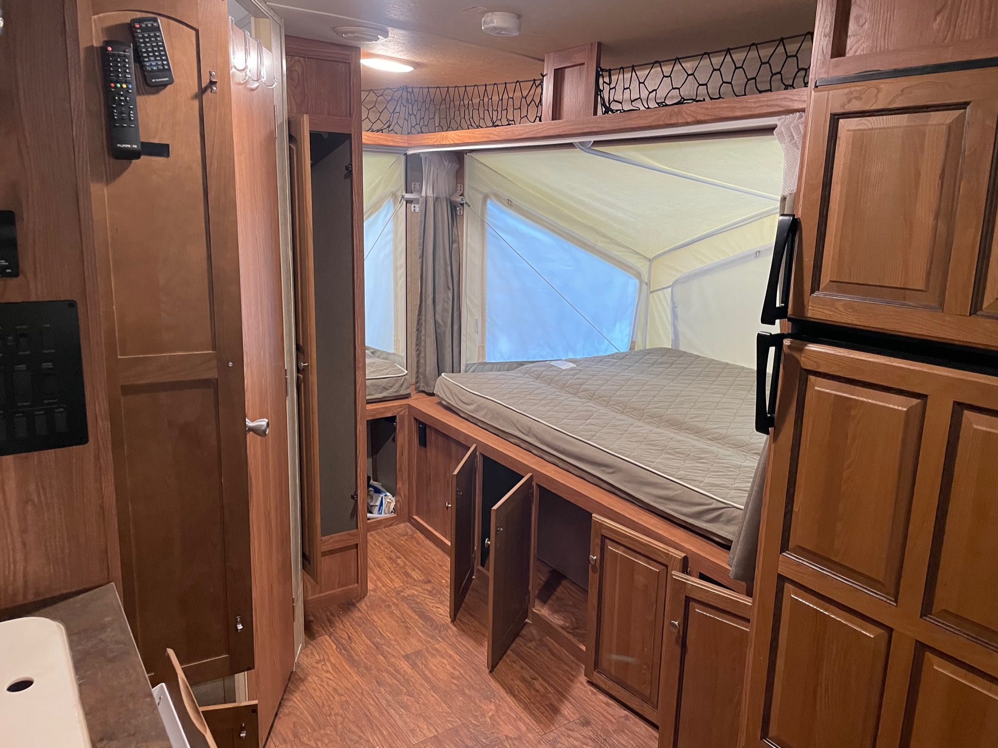 Cozy RV rental interior with pop-out bed, ample storage, and warm wood finishes. Perfect for your next adventure.. Forest River Rockwood Roo 2016